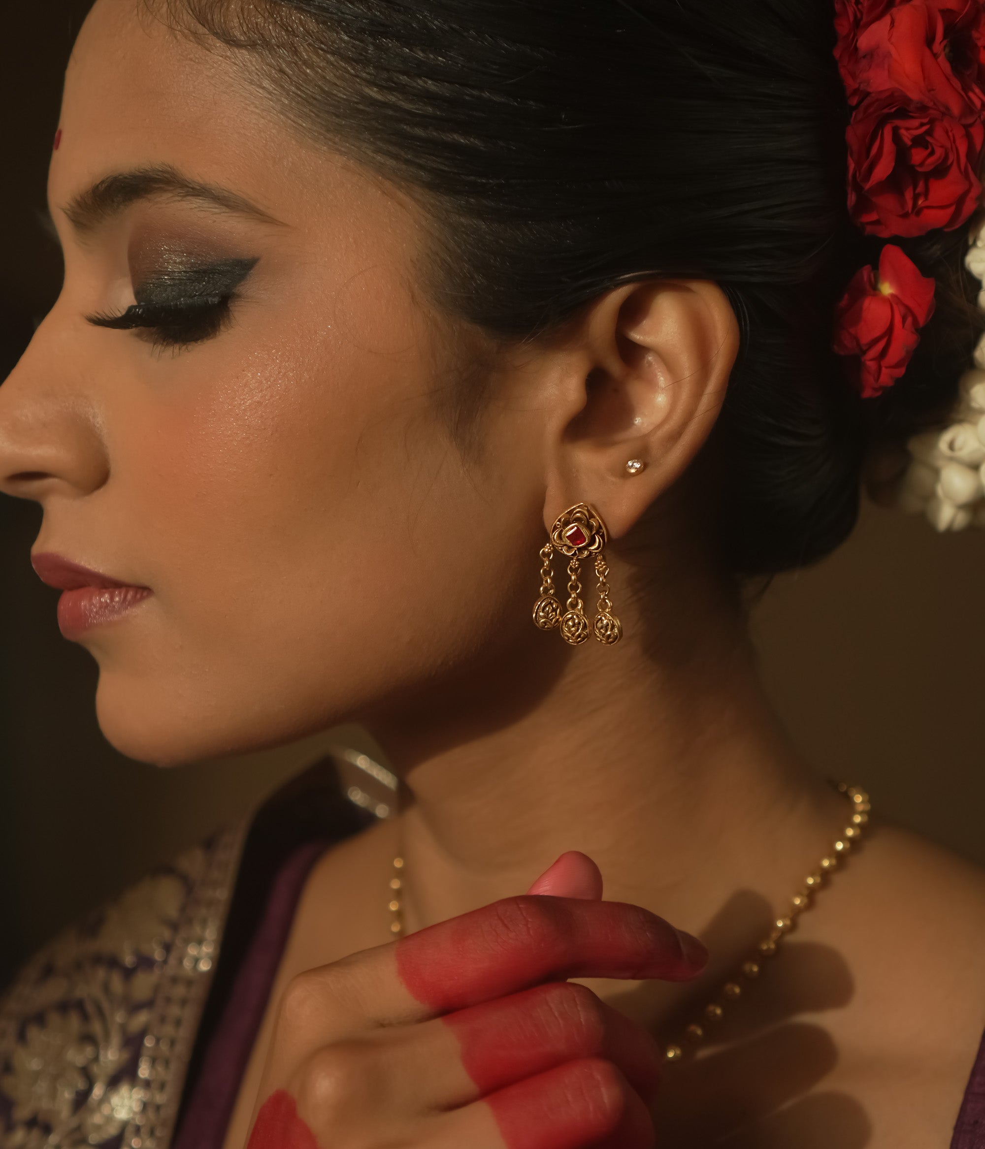Earrings with chains of tiny coins and a central ruby red Kundan stone.