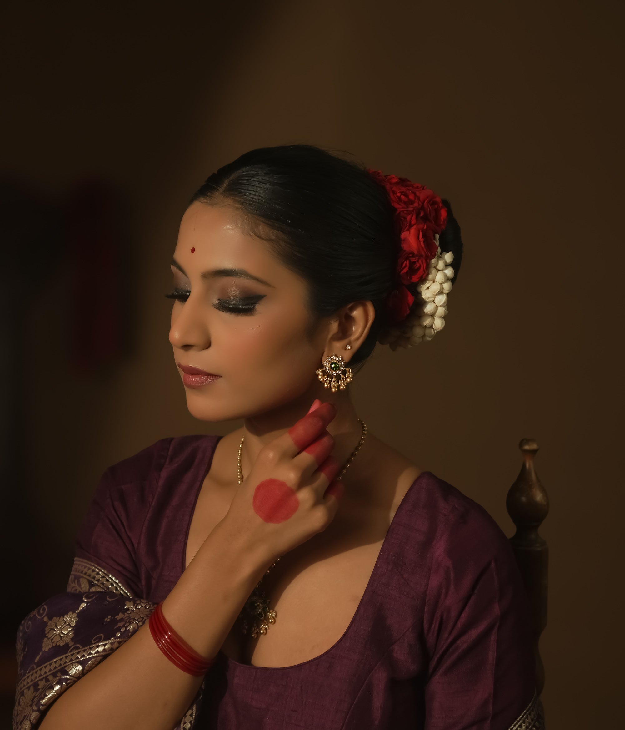 Gold-plated silver filigree earrings with a central green Kundan stone.