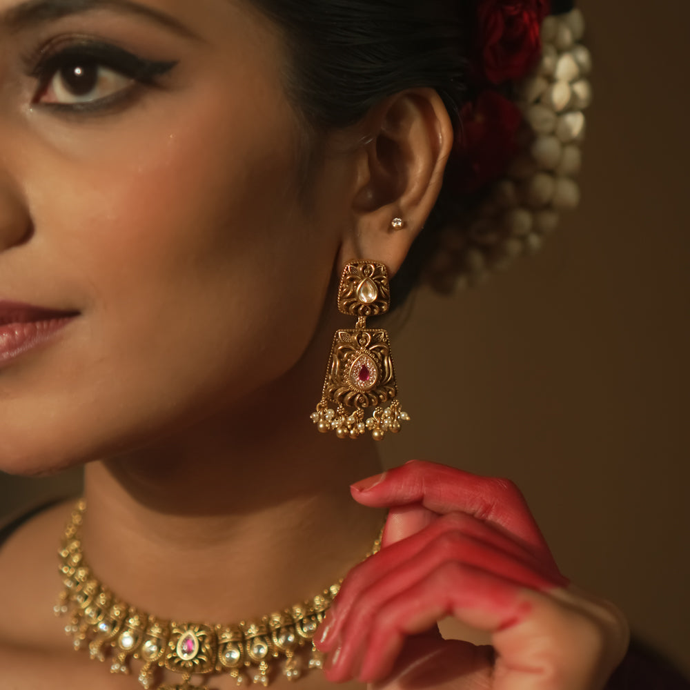 Intricate filigree earrings with teardrop gems, red stones, and pearls.