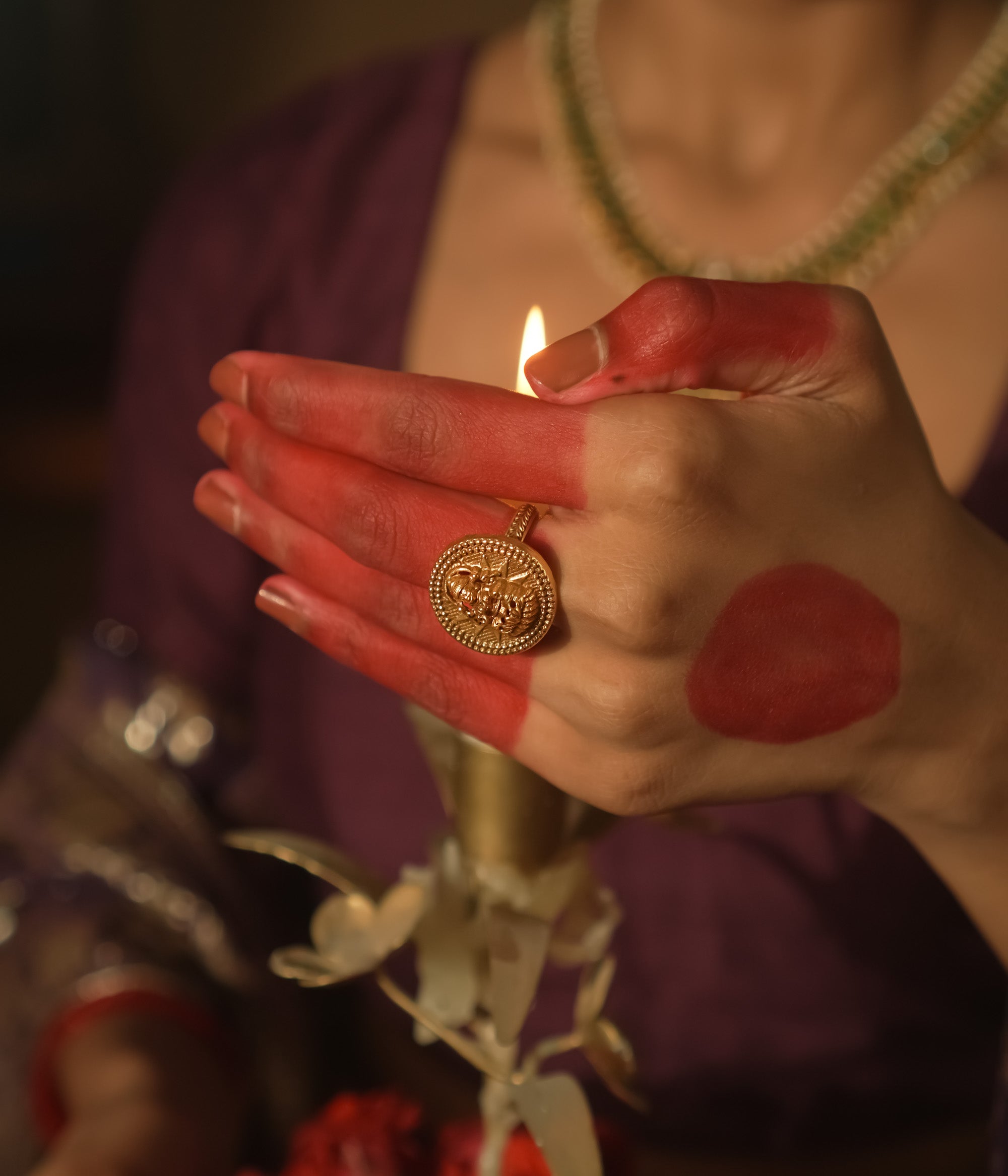 Gold ring with a Lakshmi goddess motif in a textured circular frame.