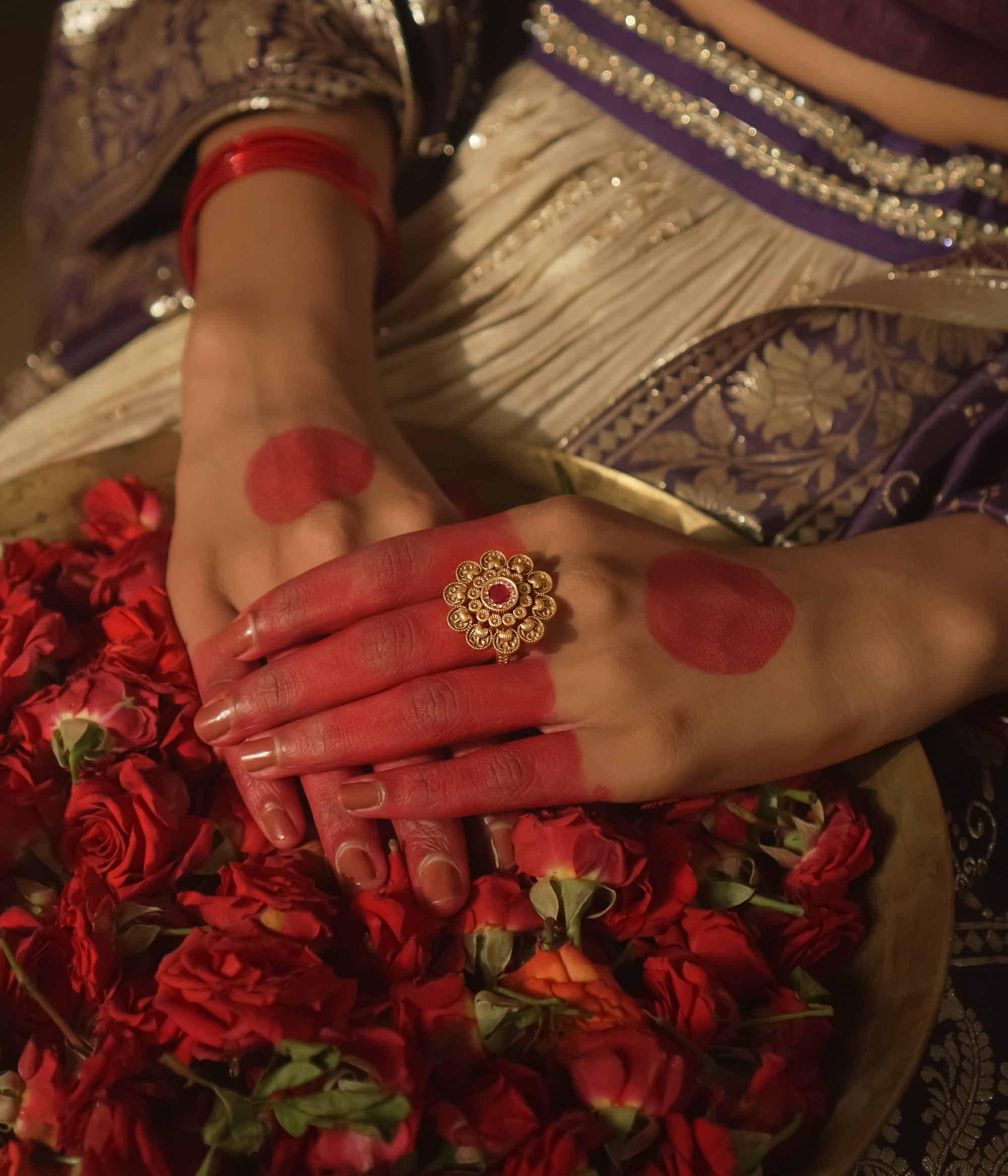 Gold-plated silver ring with a sunburst design and a central crimson gem.