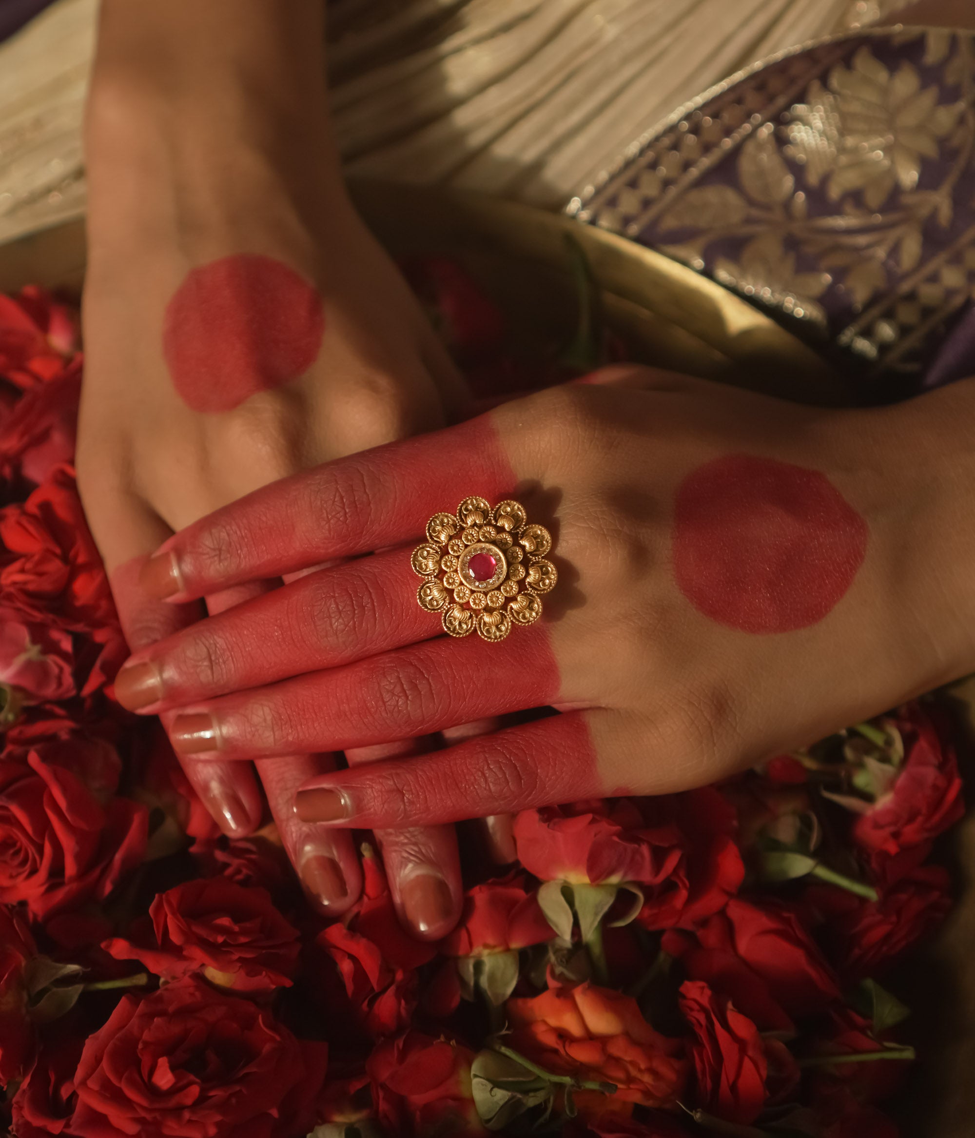 Gold-plated silver ring with a sunburst design and a central crimson gem.