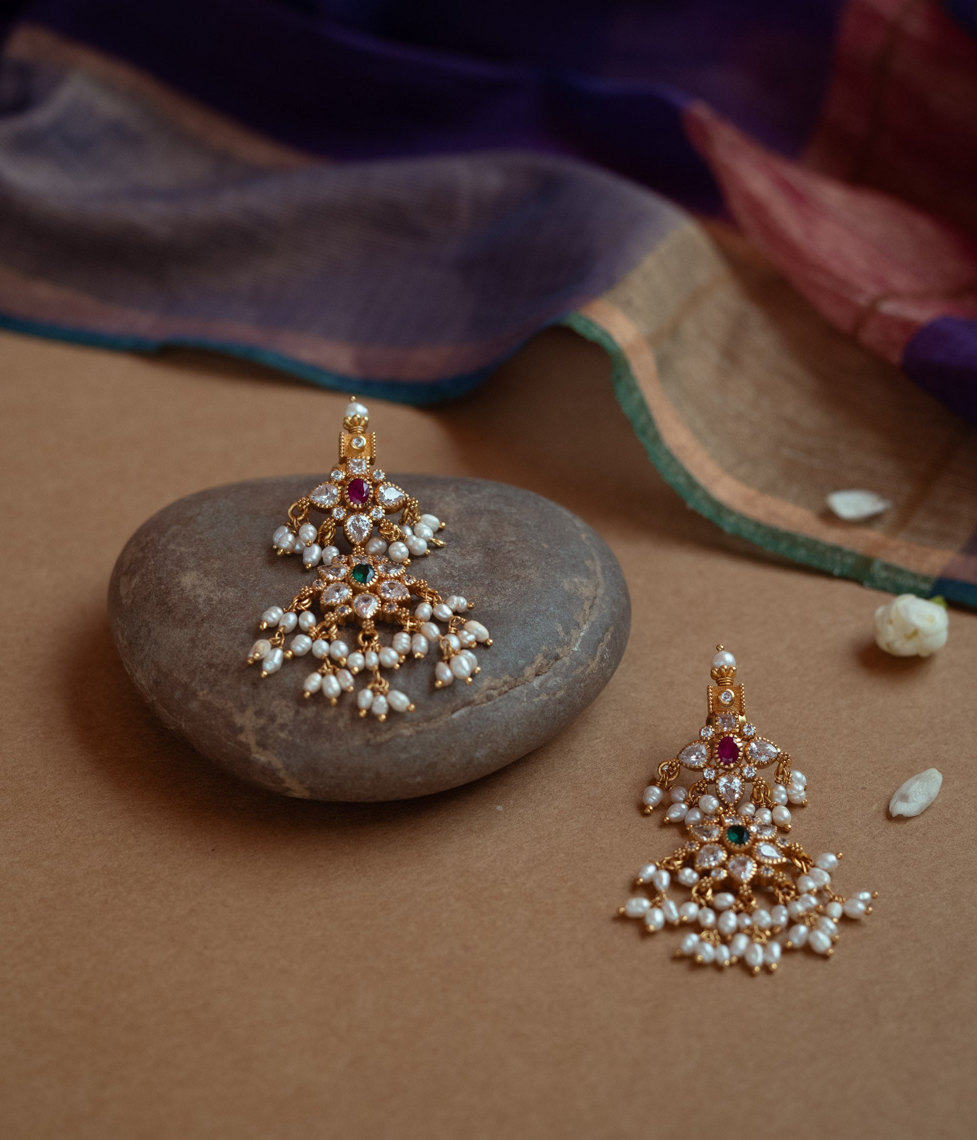 Gold drop earrings with a cluster of red, green, white cut stones, Swarovski stones, and multiple dangling pearls.