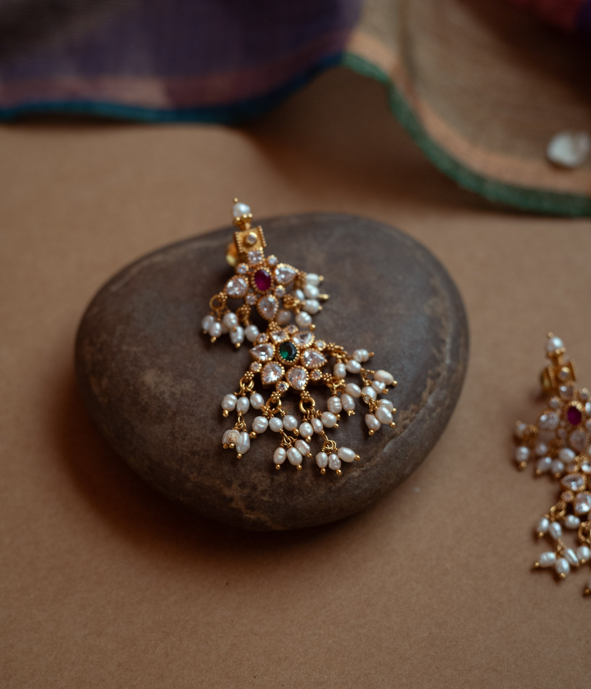 Gold drop earrings with a cluster of red, green, white cut stones, Swarovski stones, and multiple dangling pearls.