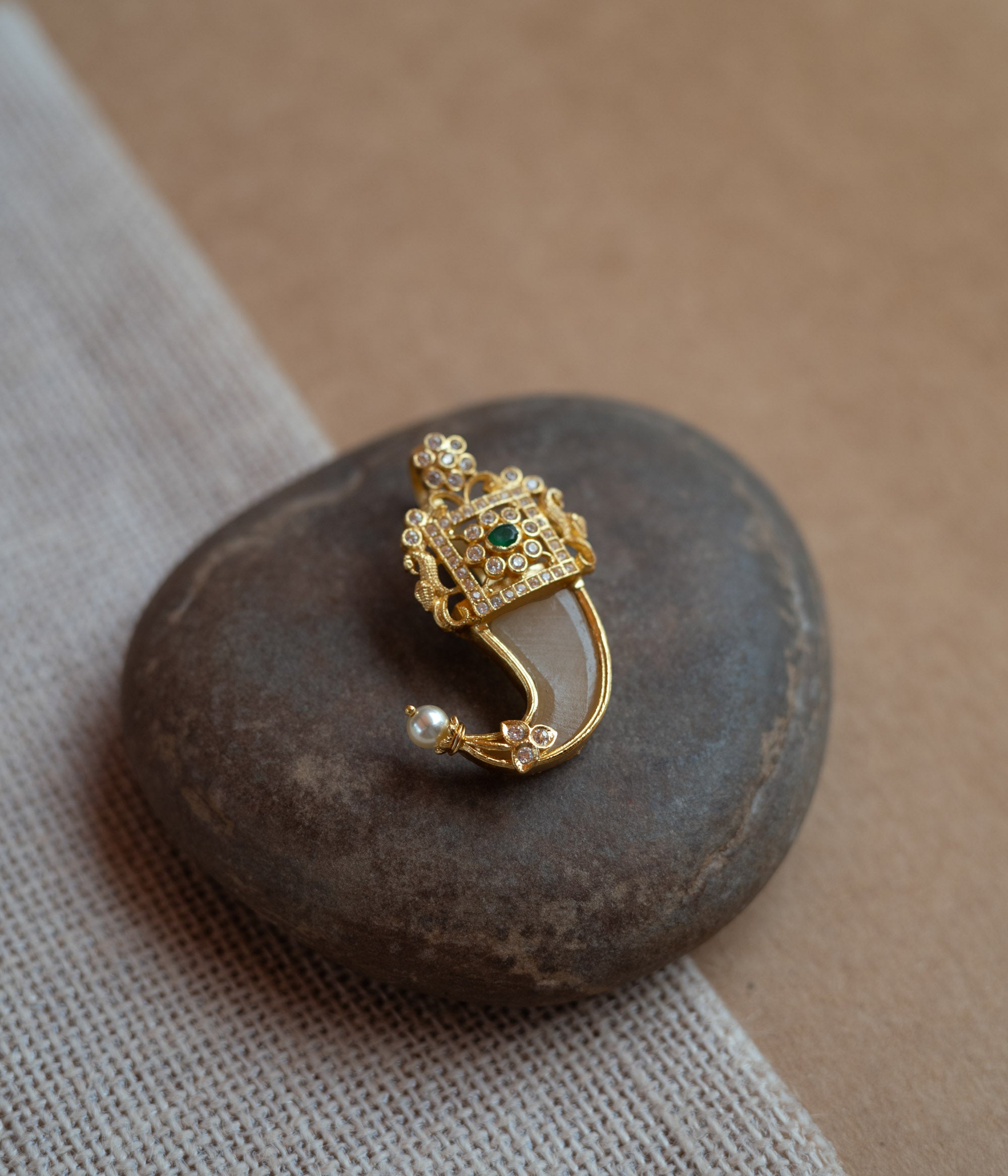 Gold amulet-shaped pendant with a prominent green spinel stone, CZ stones, and pearl drops.
