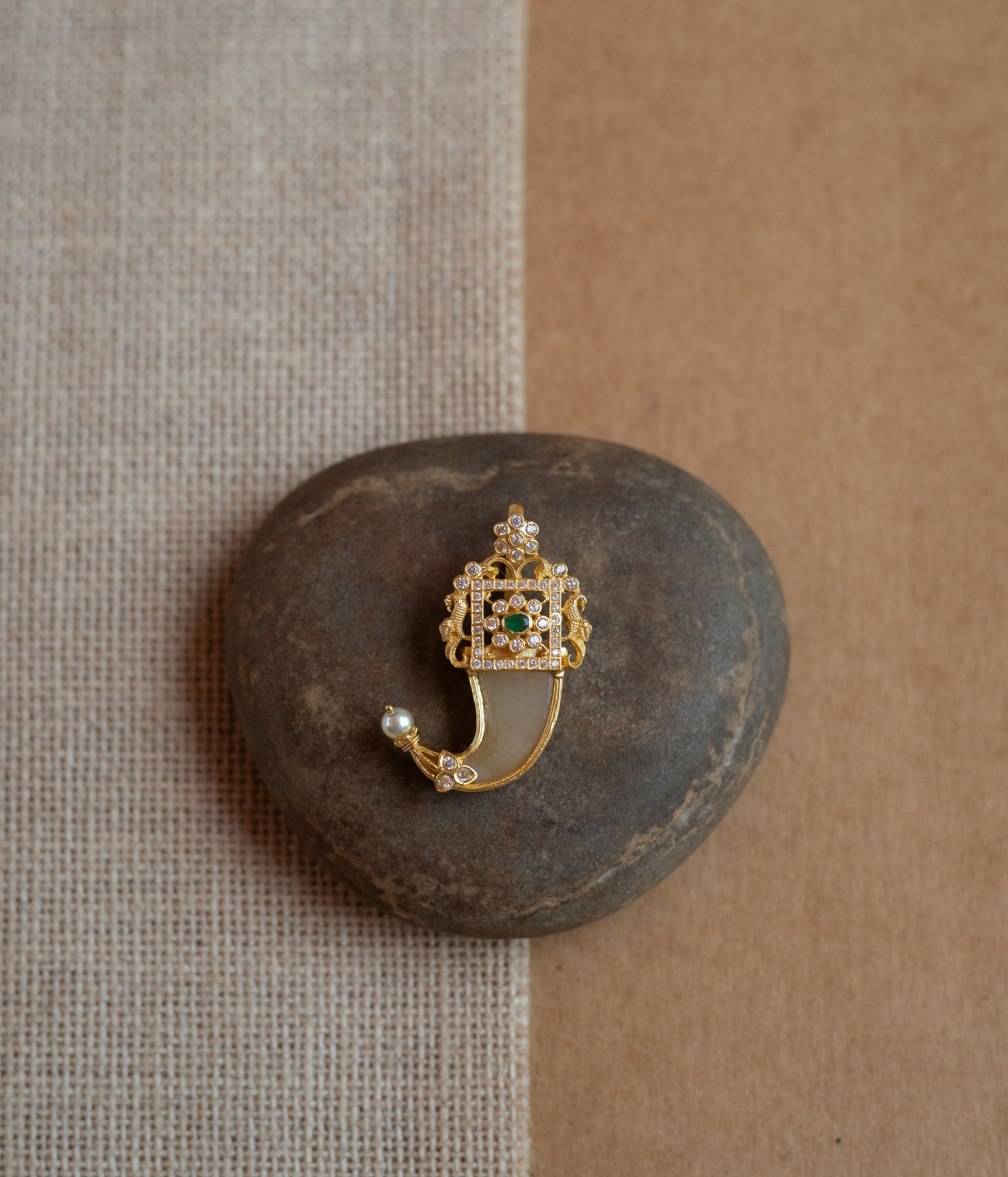 Gold amulet-shaped pendant with a prominent green spinel stone, CZ stones, and pearl drops.