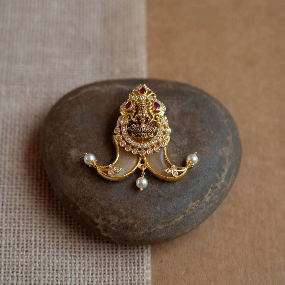 Gold amulet-shaped pendant with a goddess figure, red spinel, CZ stones, and pearls.