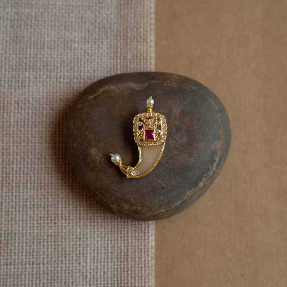Gold amulet-shaped pendant with a prominent red spinel stone, CZ stones, and pearl drops.