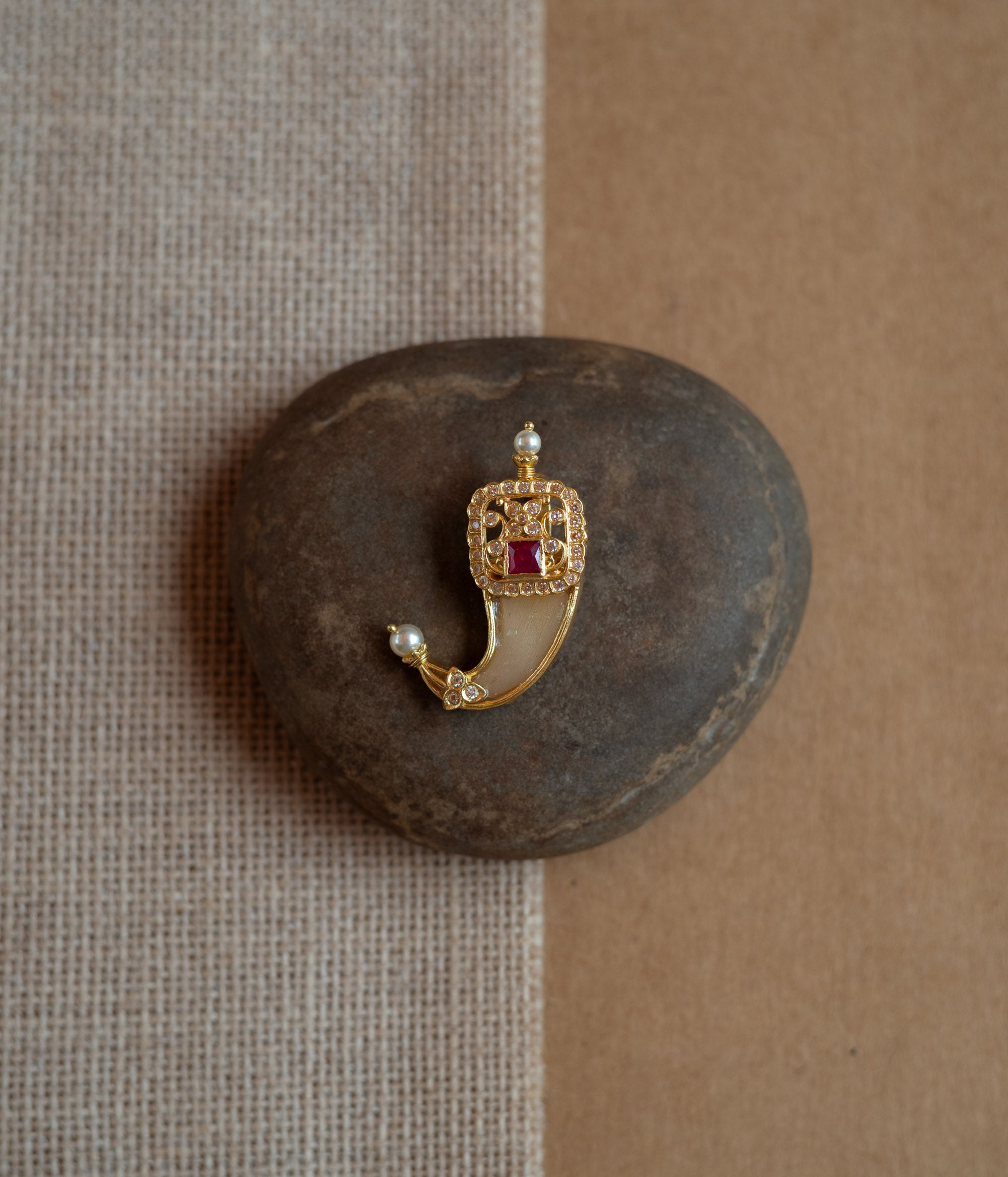 Gold amulet-shaped pendant with a prominent red spinel stone, CZ stones, and pearl drops.