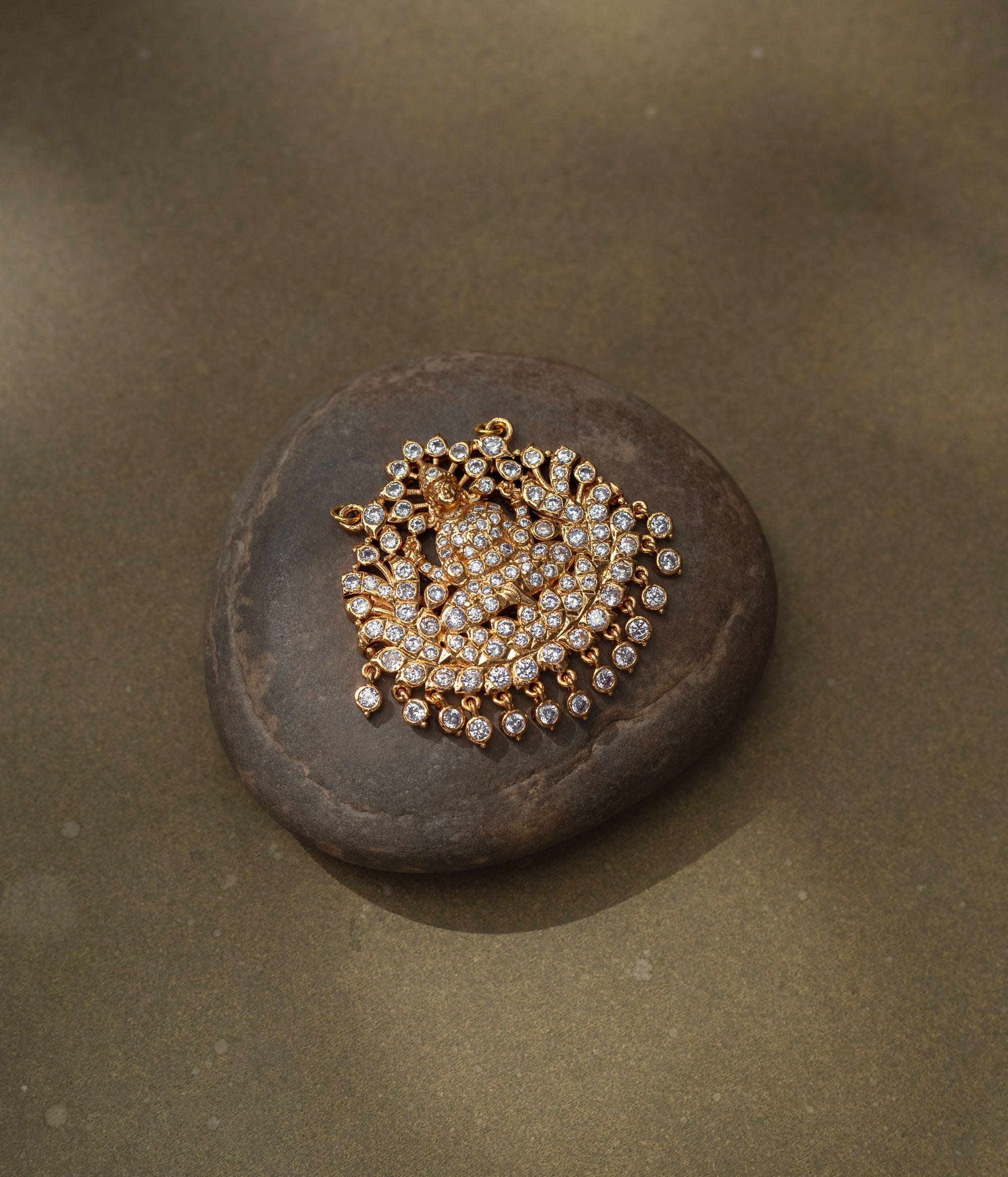 Gold pendant with goddess figure and CZ stones in a radiant circular design from Stone Collection.