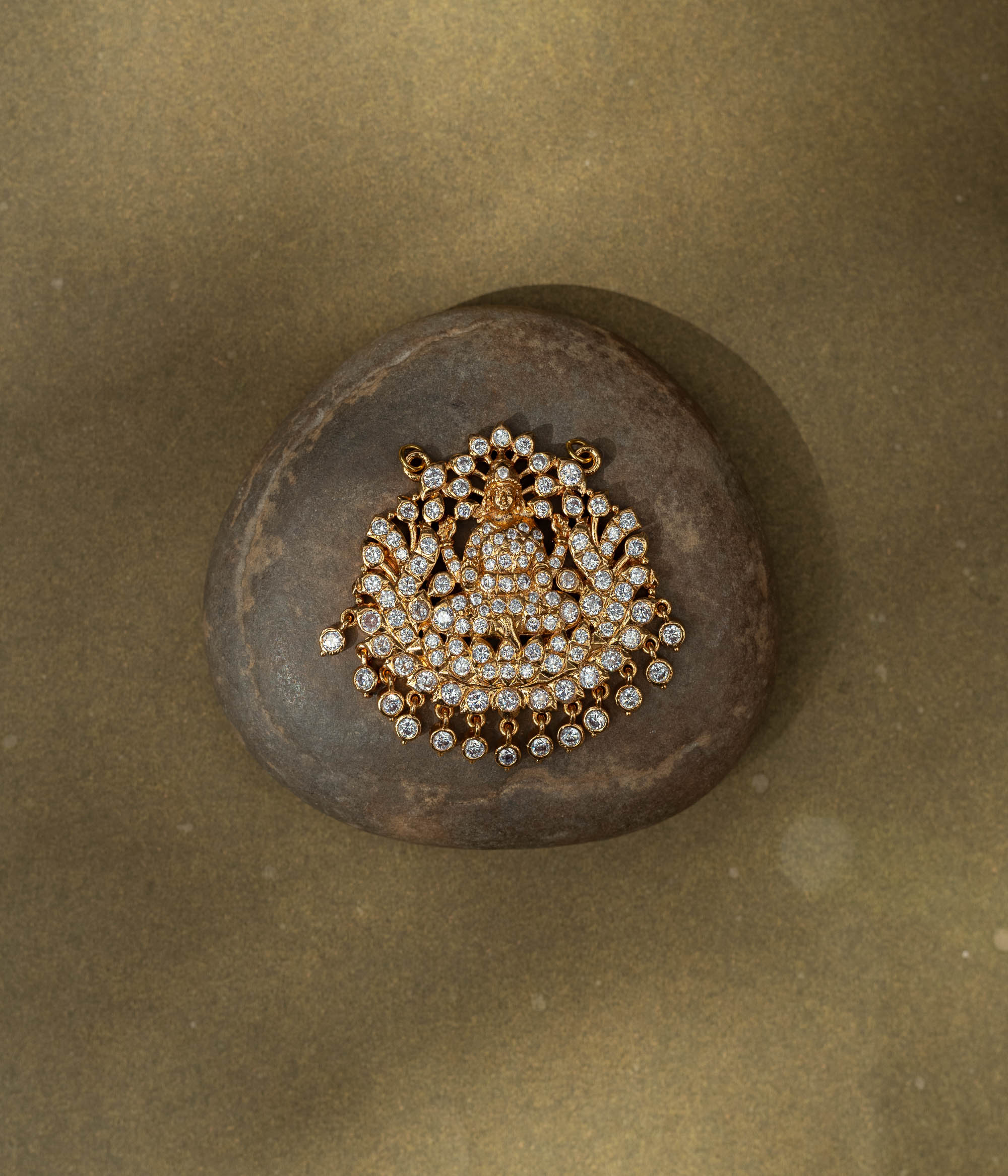 Gold pendant with goddess figure and CZ stones in a radiant circular design from Stone Collection.