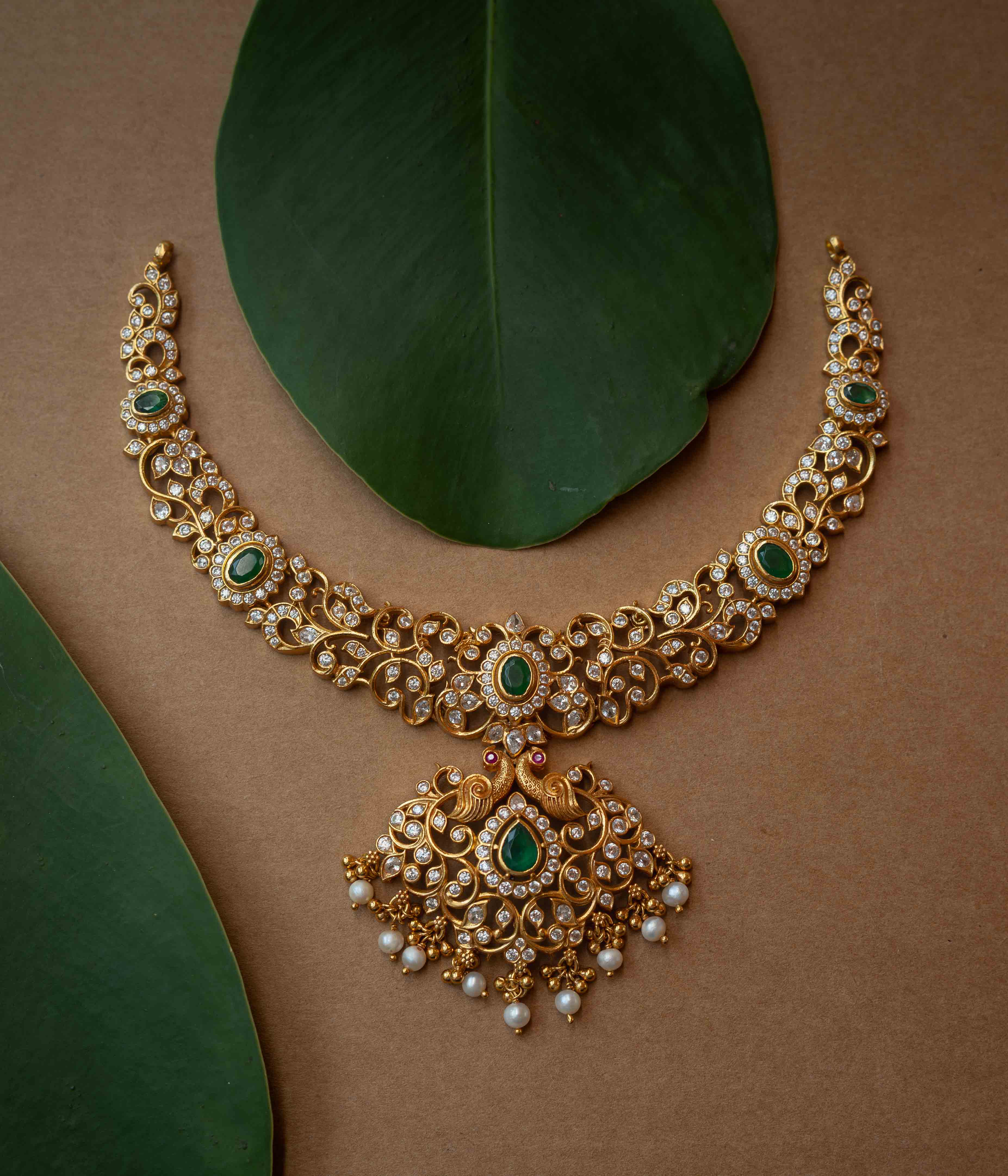 A multi-strand necklace with green, clear, and white stones and pearls.