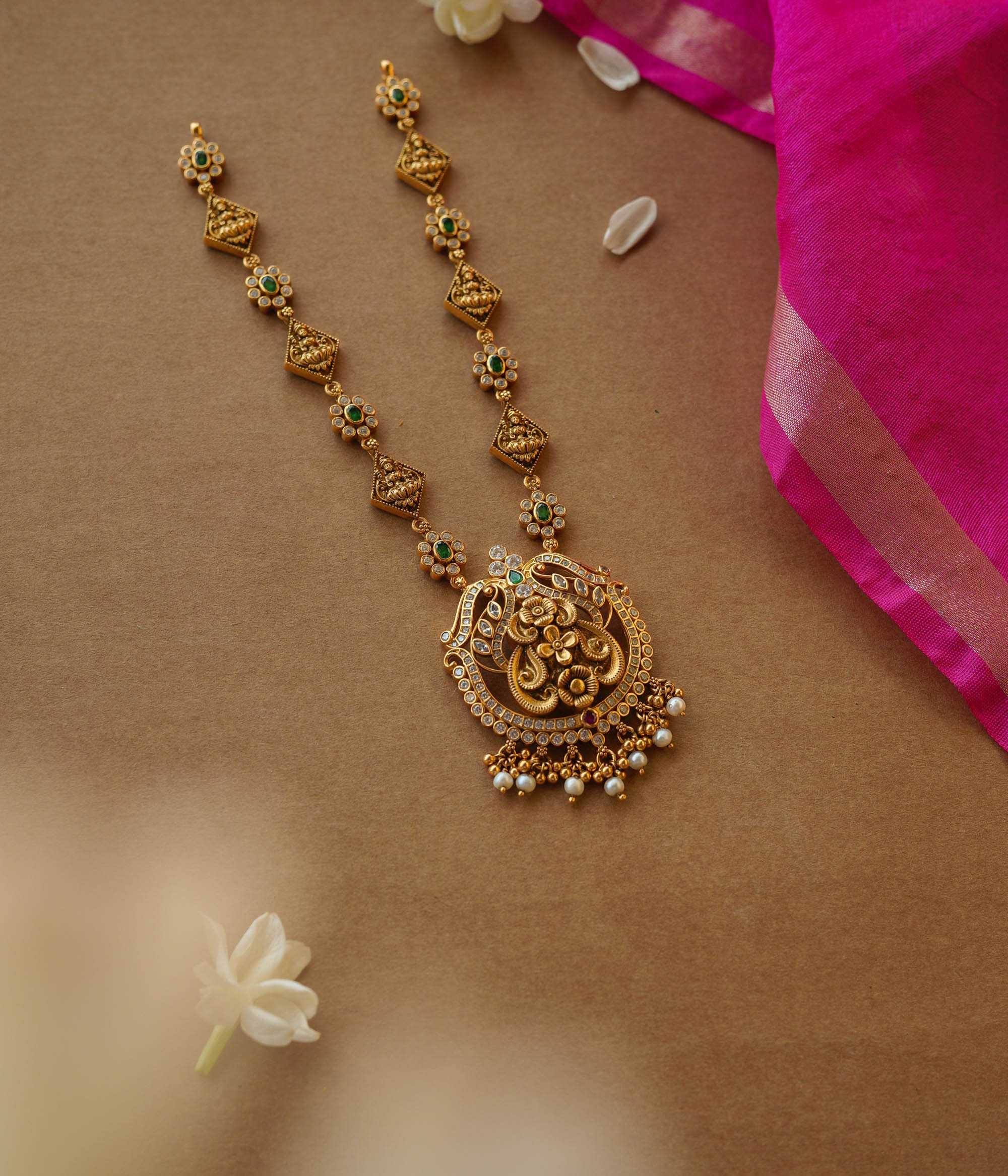 Temple-inspired gold necklace with peacock motif and Swarovski, red, and green spinal stones.