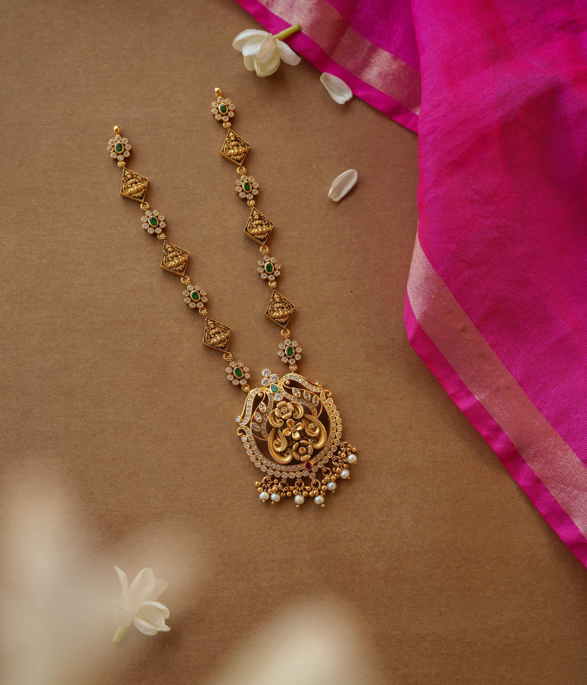 Temple-inspired gold necklace with peacock motif and Swarovski, red, and green spinal stones.