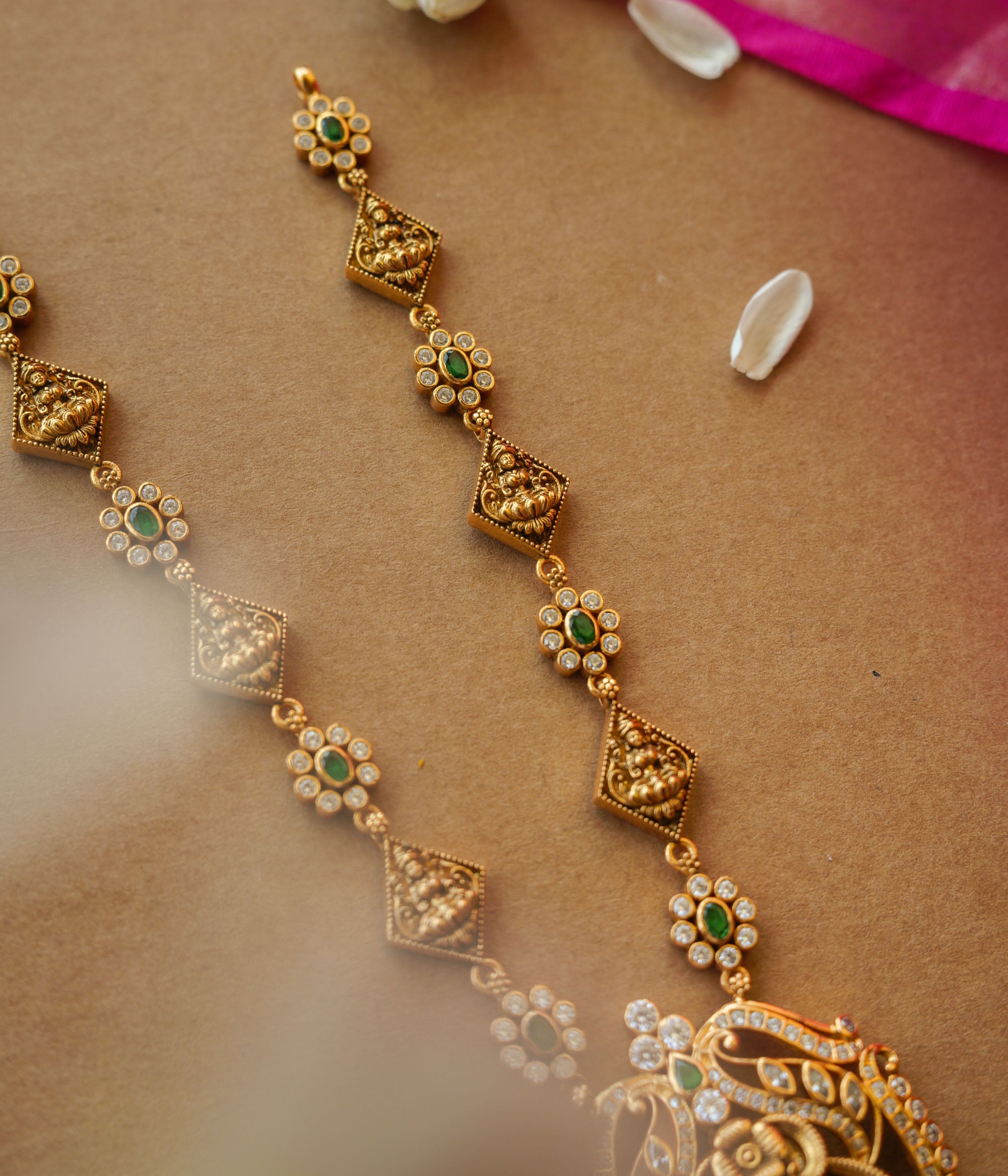 Temple-inspired gold necklace with peacock motif and Swarovski, red, and green spinal stones.