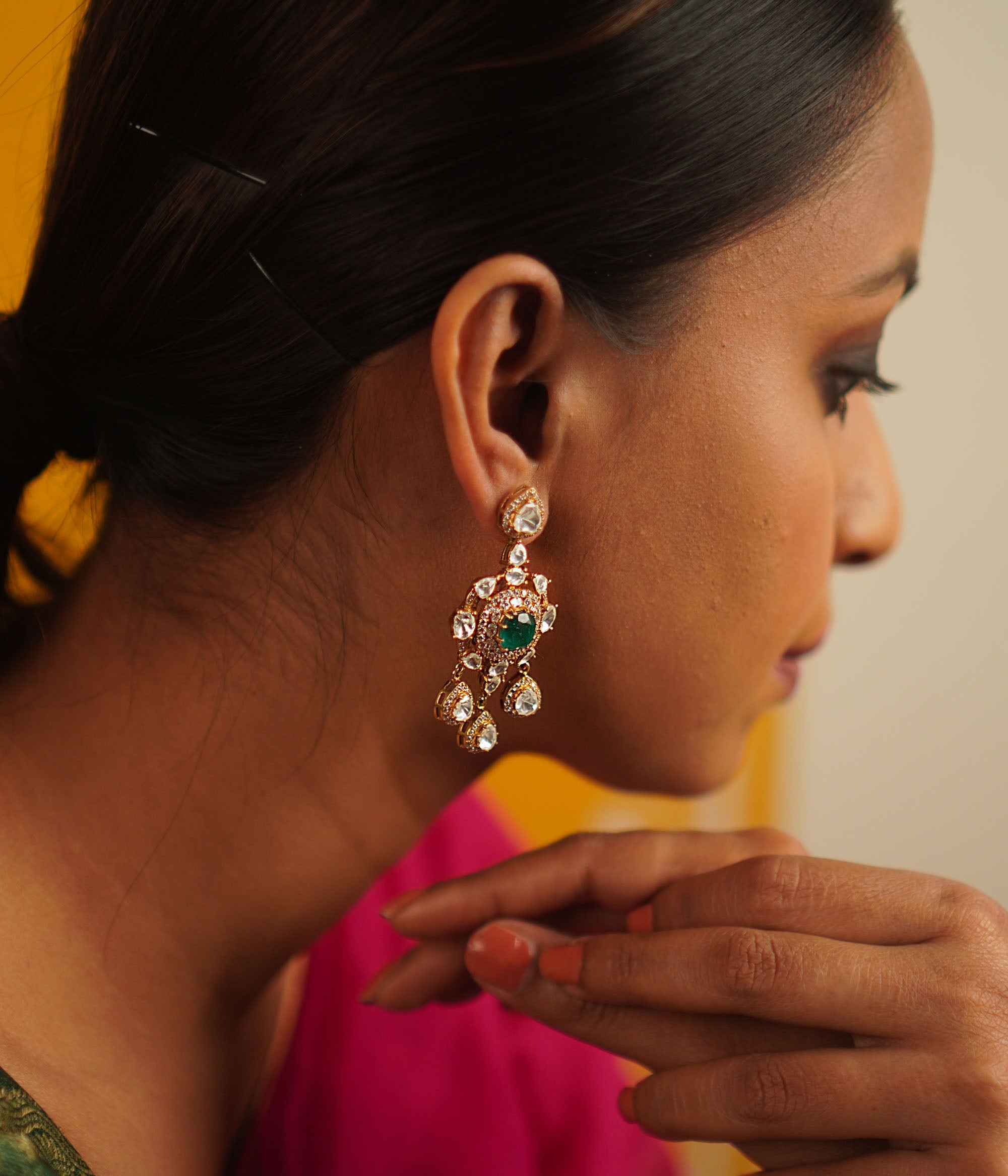 The Sadabahar earrings, meticulously crafted in gold-plated silver, showcase a delicate interplay of polki, green spinel, and CZ stones. Infused with vintage charm, this exquisite design radiates timeless elegance.