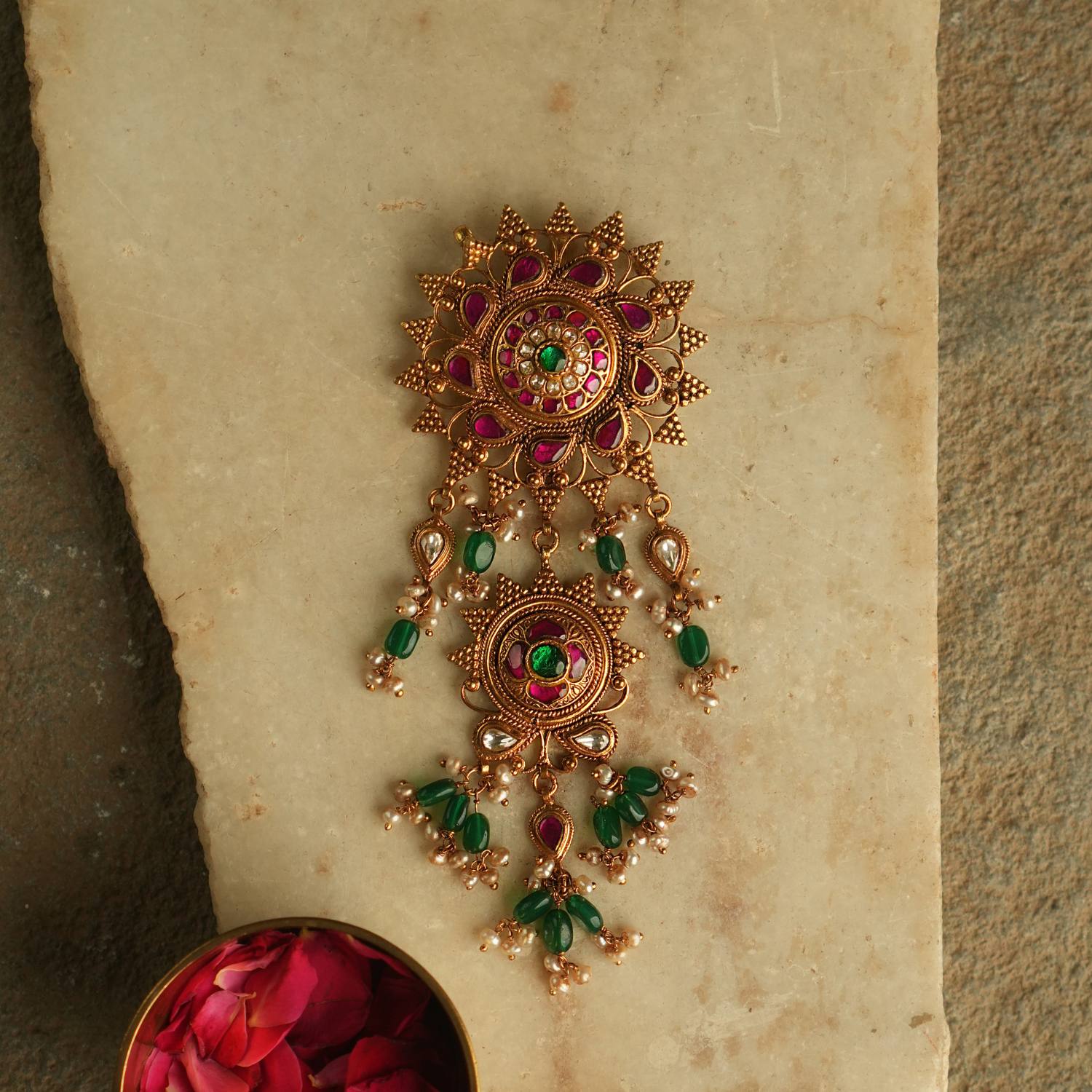 Blending traditional elegance with contemporary allure, this gold-plated pendant is adorned with red, green, and white Kundan stones, accented by luminous pearls for a timeless and sophisticated look.