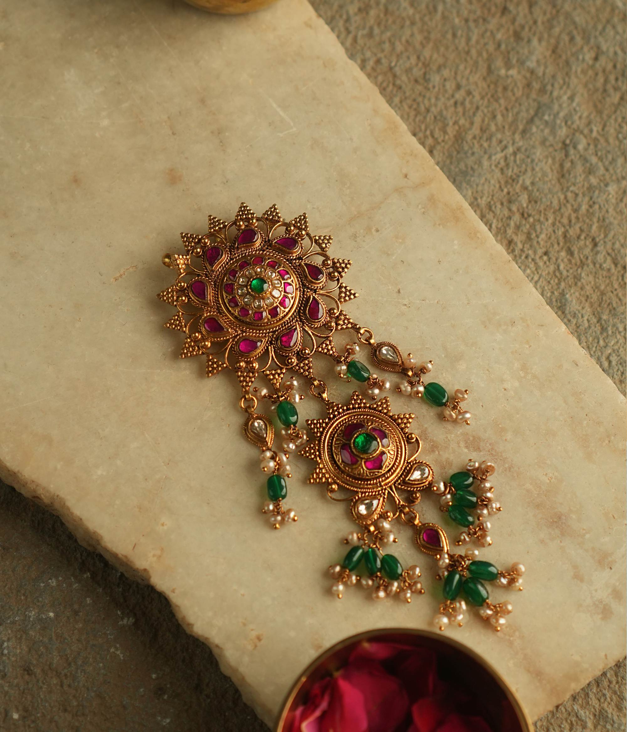 Blending traditional elegance with contemporary allure, this gold-plated pendant is adorned with red, green, and white Kundan stones, accented by luminous pearls for a timeless and sophisticated look.