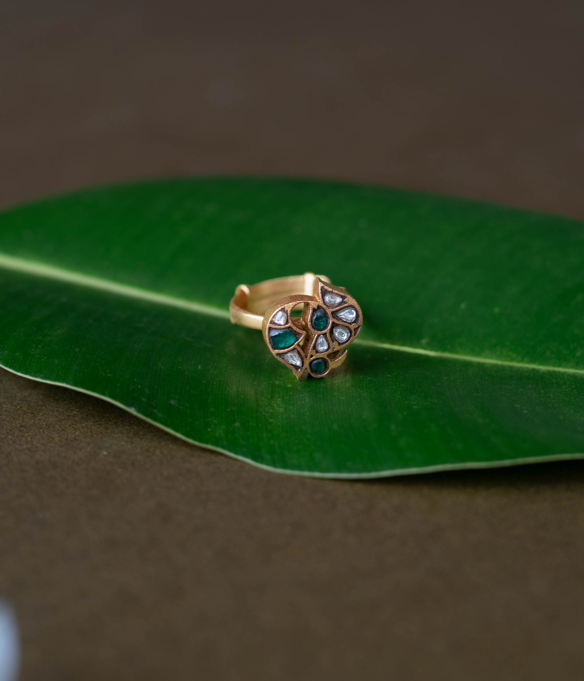 Kundan ring, Sparkling petals embrace a bird in a whisper of nature's grace.