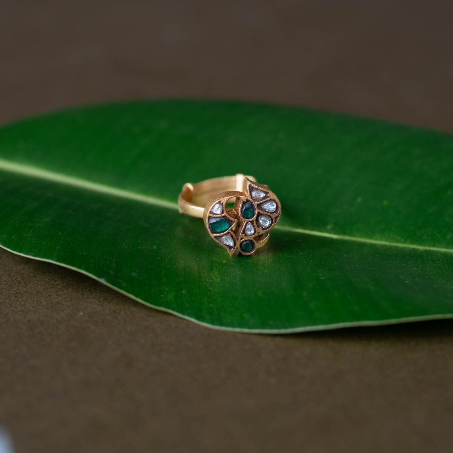 Kundan ring, Sparkling petals embrace a bird in a whisper of nature's grace.