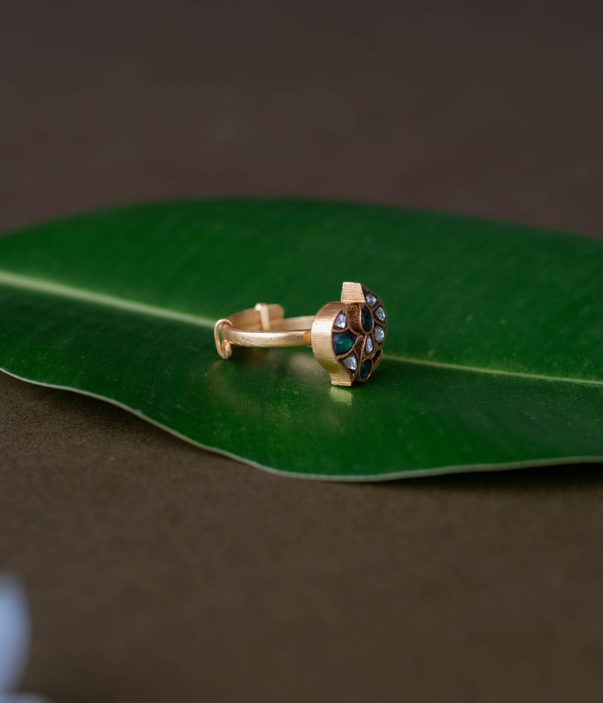 Kundan ring, Sparkling petals embrace a bird in a whisper of nature's grace.
