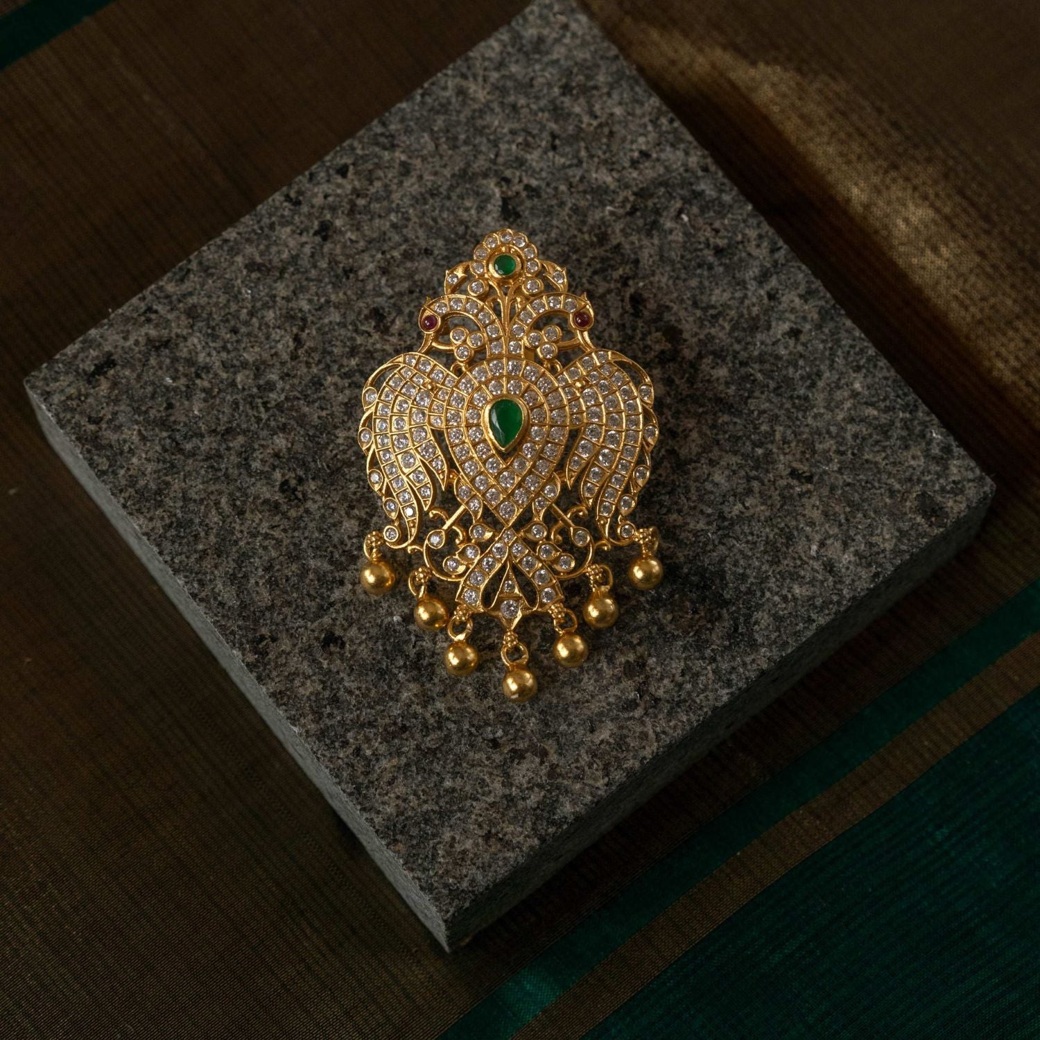 Exquisite handcrafted gold-plated peacock pendant, adorned with dazzling stones and golden beads—an elegant fusion of tradition and opulence.