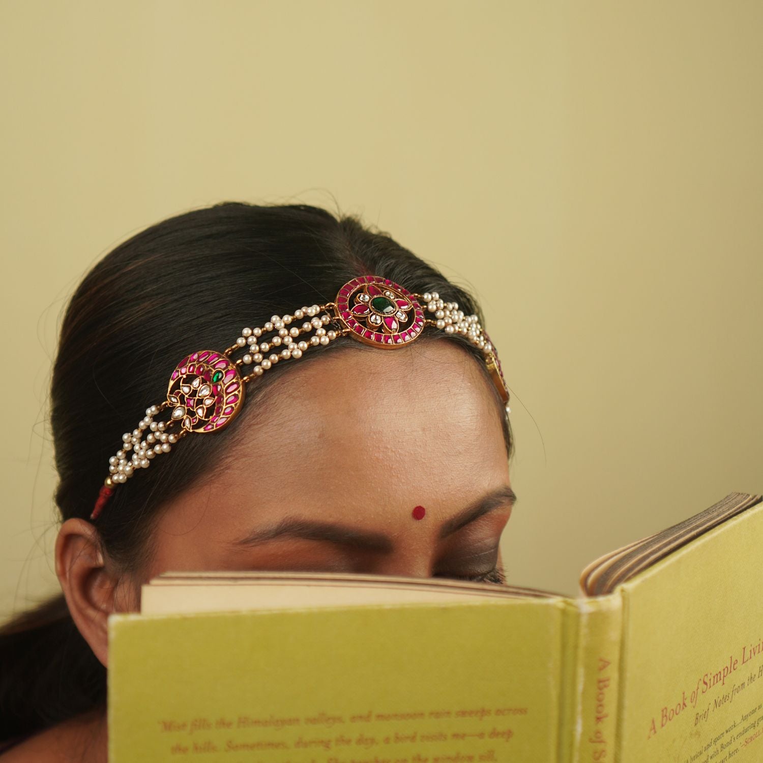 Sarayi Mathapatti: A graceful fusion of tradition and charm, featuring pearls and floral Kundan accents in red, white, and green, set in gold-plated silver—a piece that echoes timeless stories.
