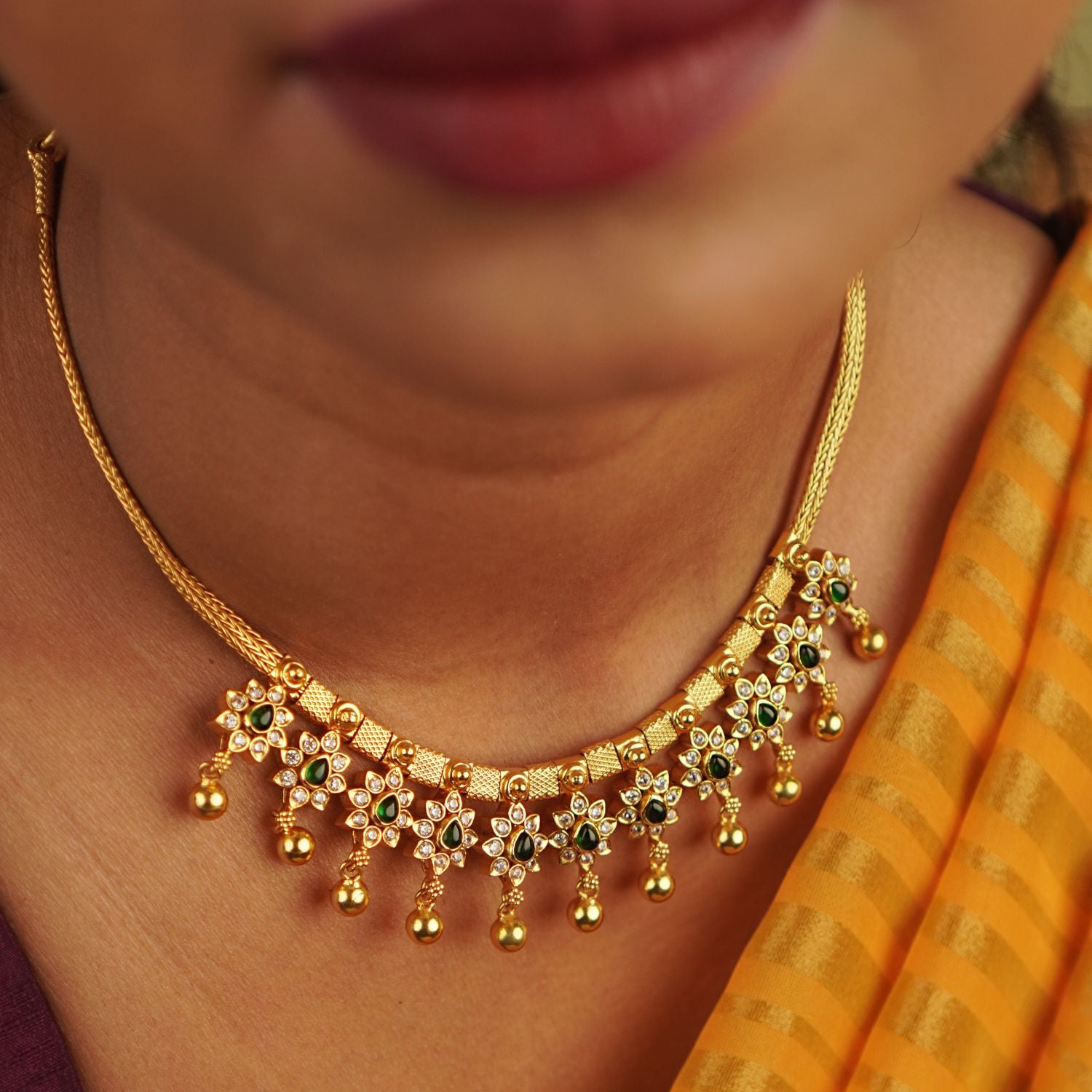 Handcrafted in gold-plated silver, this necklace features delicate red spinel and CZ stone droplets, seamlessly blending elegance with a touch of whimsical floral charm.