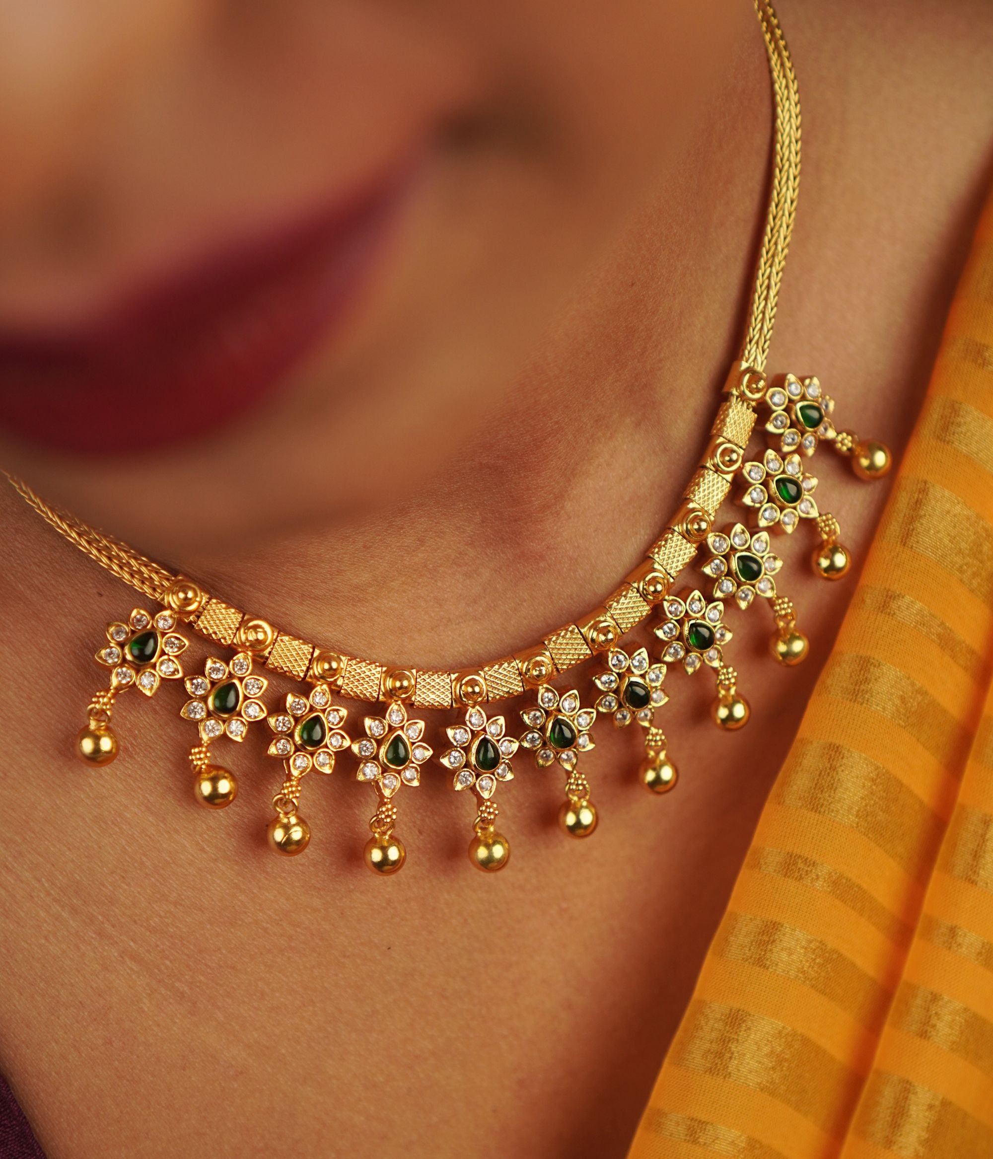Handcrafted in gold-plated silver, this necklace features delicate red spinel and CZ stone droplets, seamlessly blending elegance with a touch of whimsical floral charm.