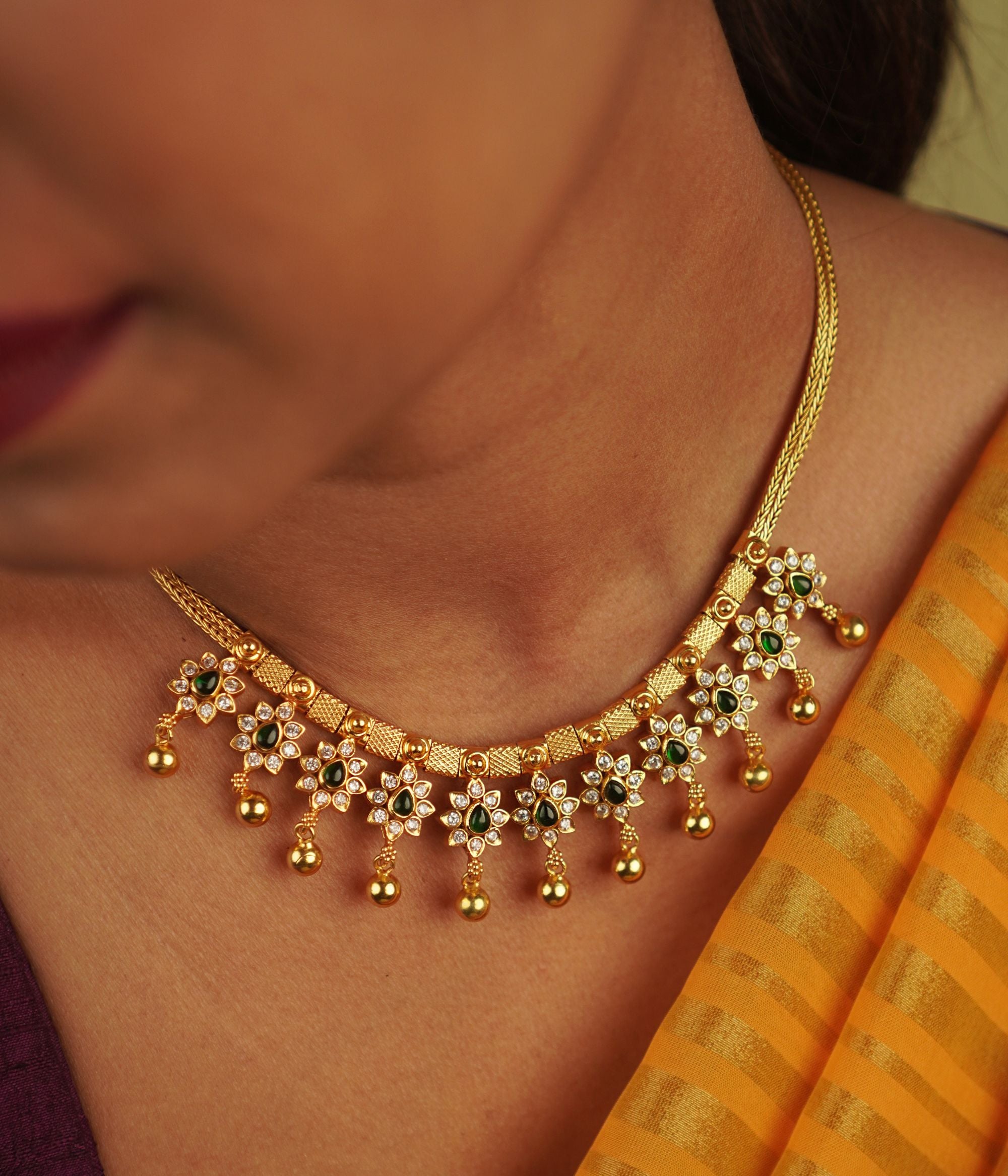 Handcrafted in gold-plated silver, this necklace features delicate red spinel and CZ stone droplets, seamlessly blending elegance with a touch of whimsical floral charm.
