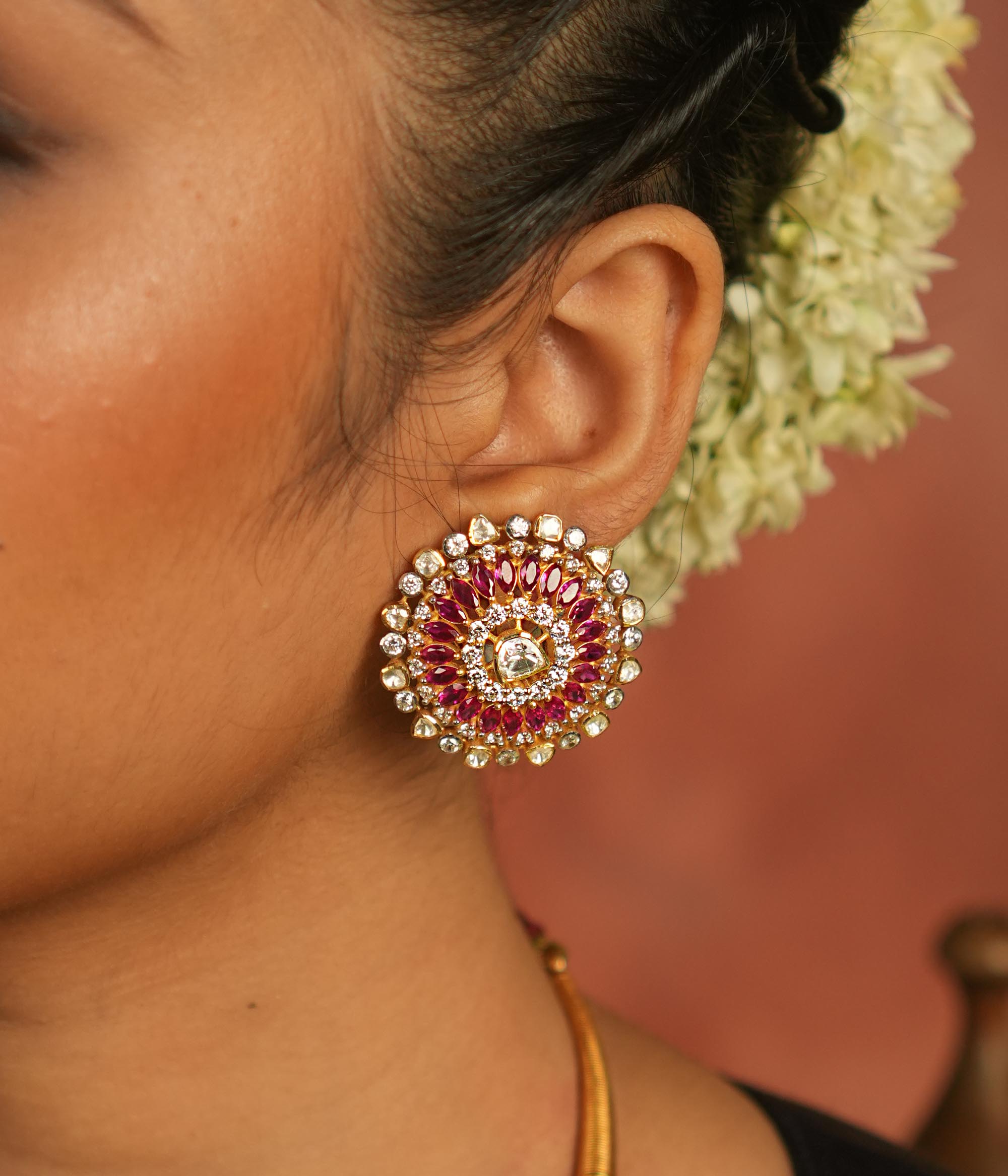 These Moissanite Polki stud earrings, adorned with CZ stones and a stunning pink tourmaline cut stone, carry the essence of Victorian elegance. Each sparkle whispers romance, making these earrings a timeless treasure that echoes the charm of a bygone era.