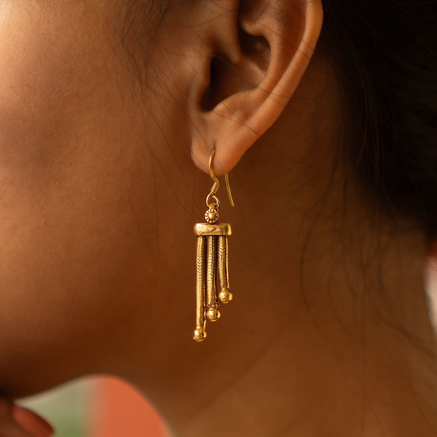 These Shaleena antique gold-plated silver dangler earrings offer a perfect blend of simplicity and sophistication, embodying understated elegance in every detail.