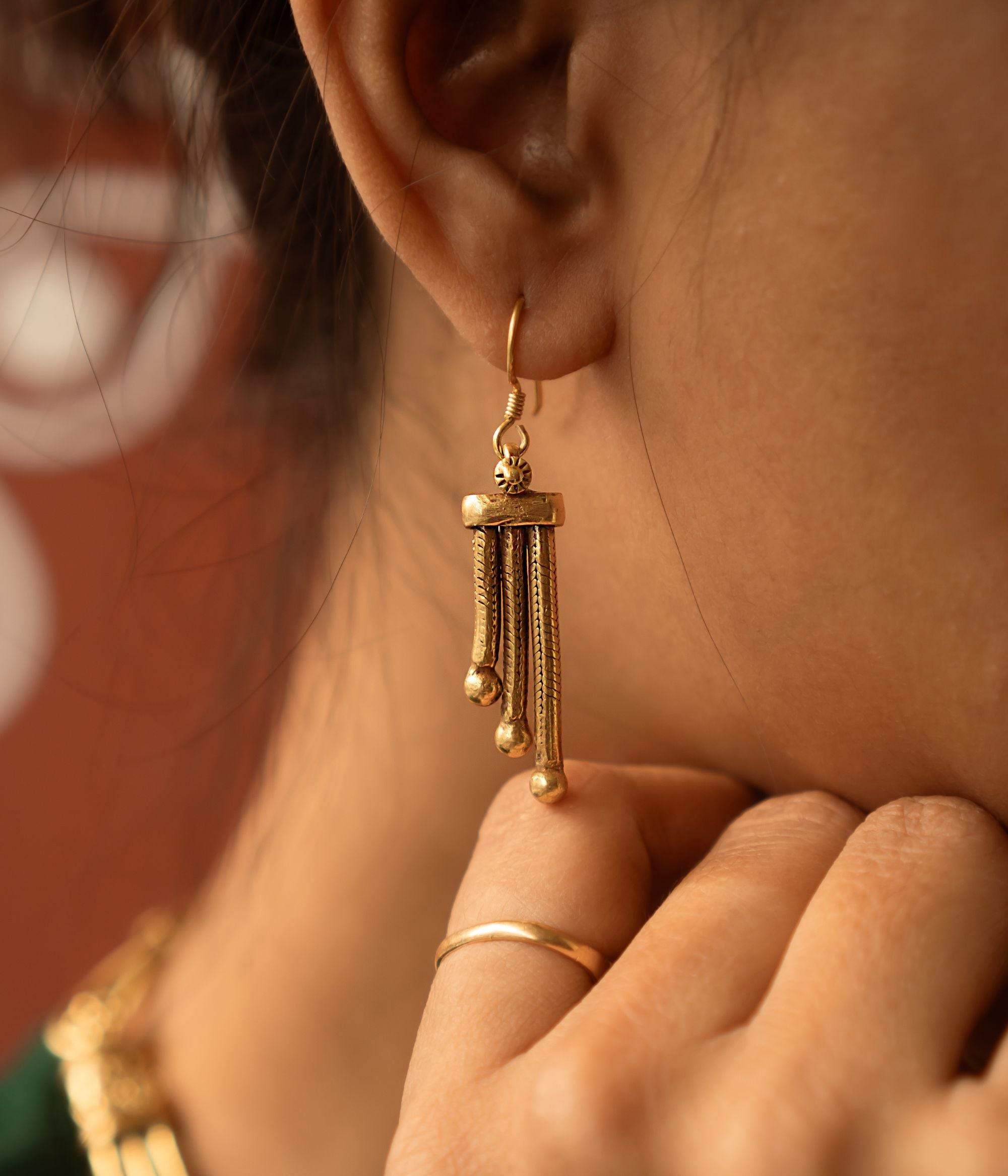 These Shaleena antique gold-plated silver dangler earrings offer a perfect blend of simplicity and sophistication, embodying understated elegance in every detail.