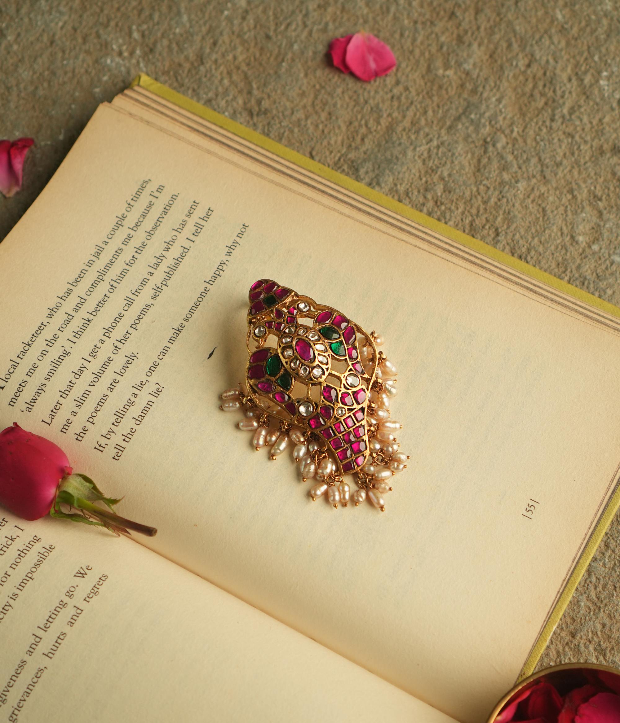 This pendant, adorned with red, white, and green Kundan stones and pearls, exudes timeless elegance. Meticulously crafted, it beautifully enhances your essence with a perfect blend of opulence and sophistication.