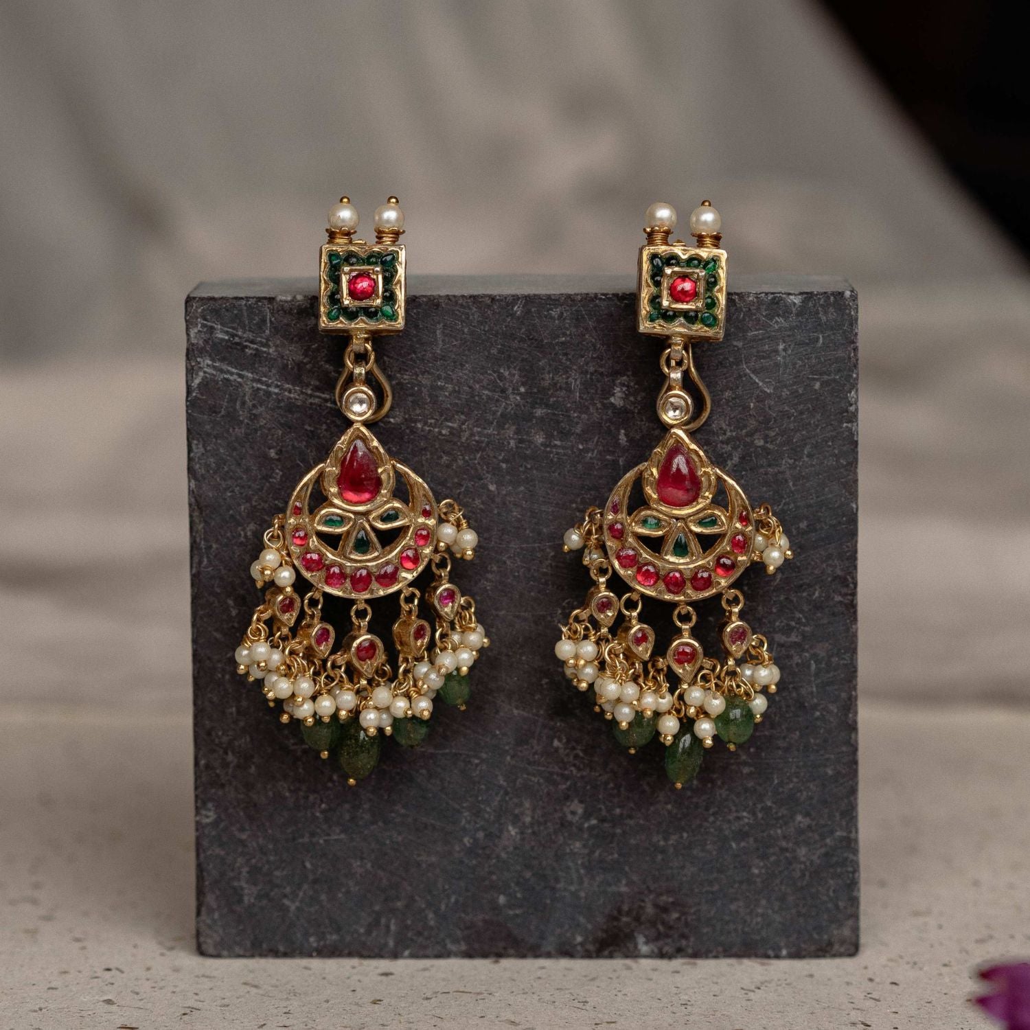 Embrace royal elegance with these enchanting Chandbali earrings, where vibrant gemstones and intricate engravings weave a tale of India's regal legacy.