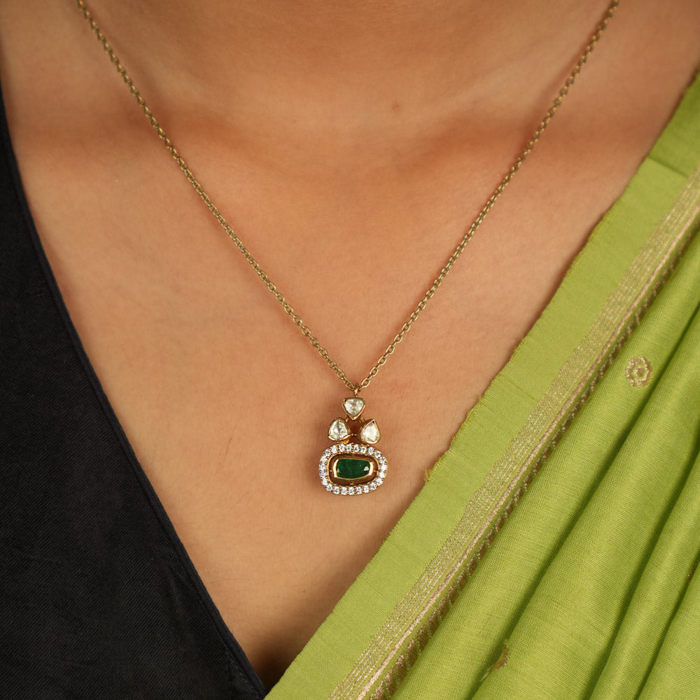 Geometric elegance redefined! This gold-plated silver pendant features an oval green gemstone at its heart, embraced by shimmering Moissanite Polki and CZ stones. A seamless blend of modern luxury and timeless charm.