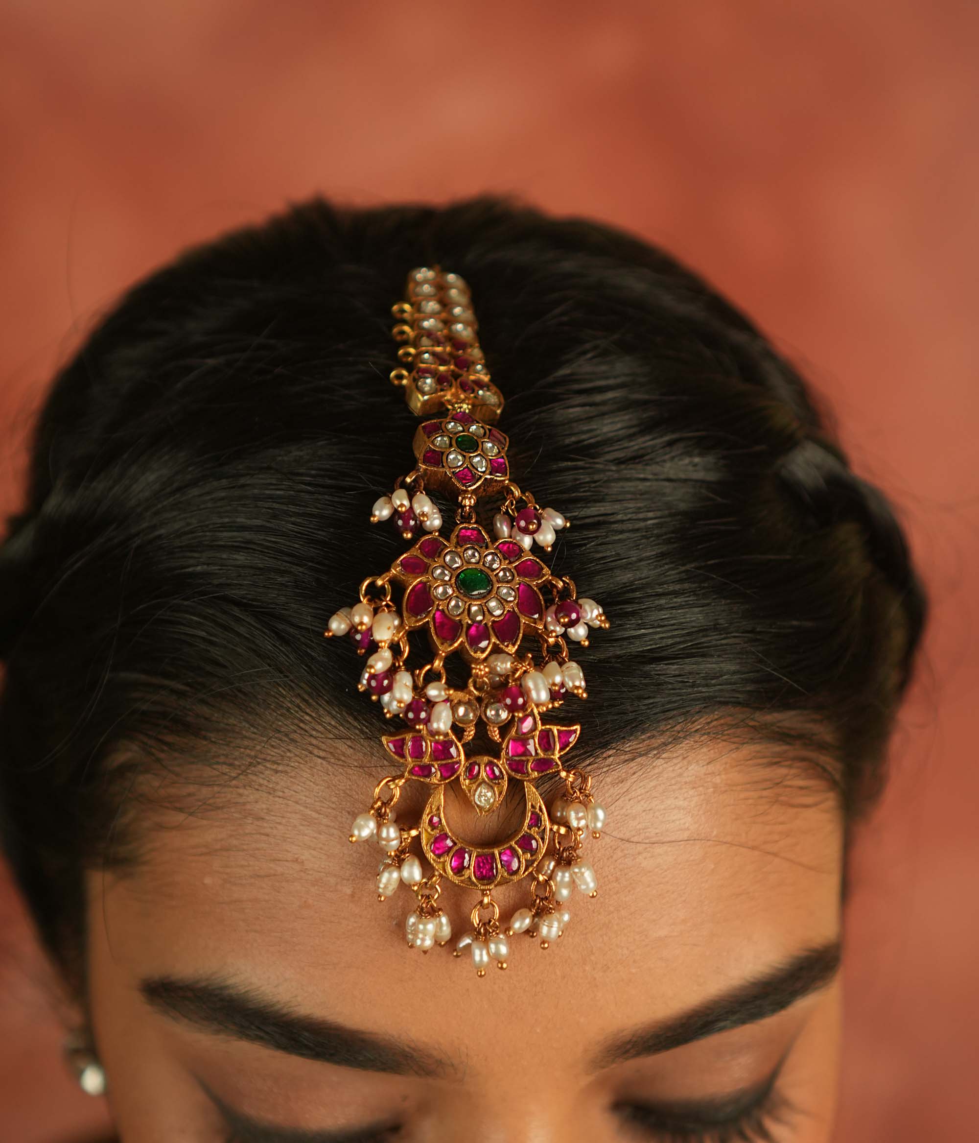 Ethereal bloom reborn! A floral Kundan maangtika adorned with pearls and red beads, where celestial grace meets timeless splendor.
