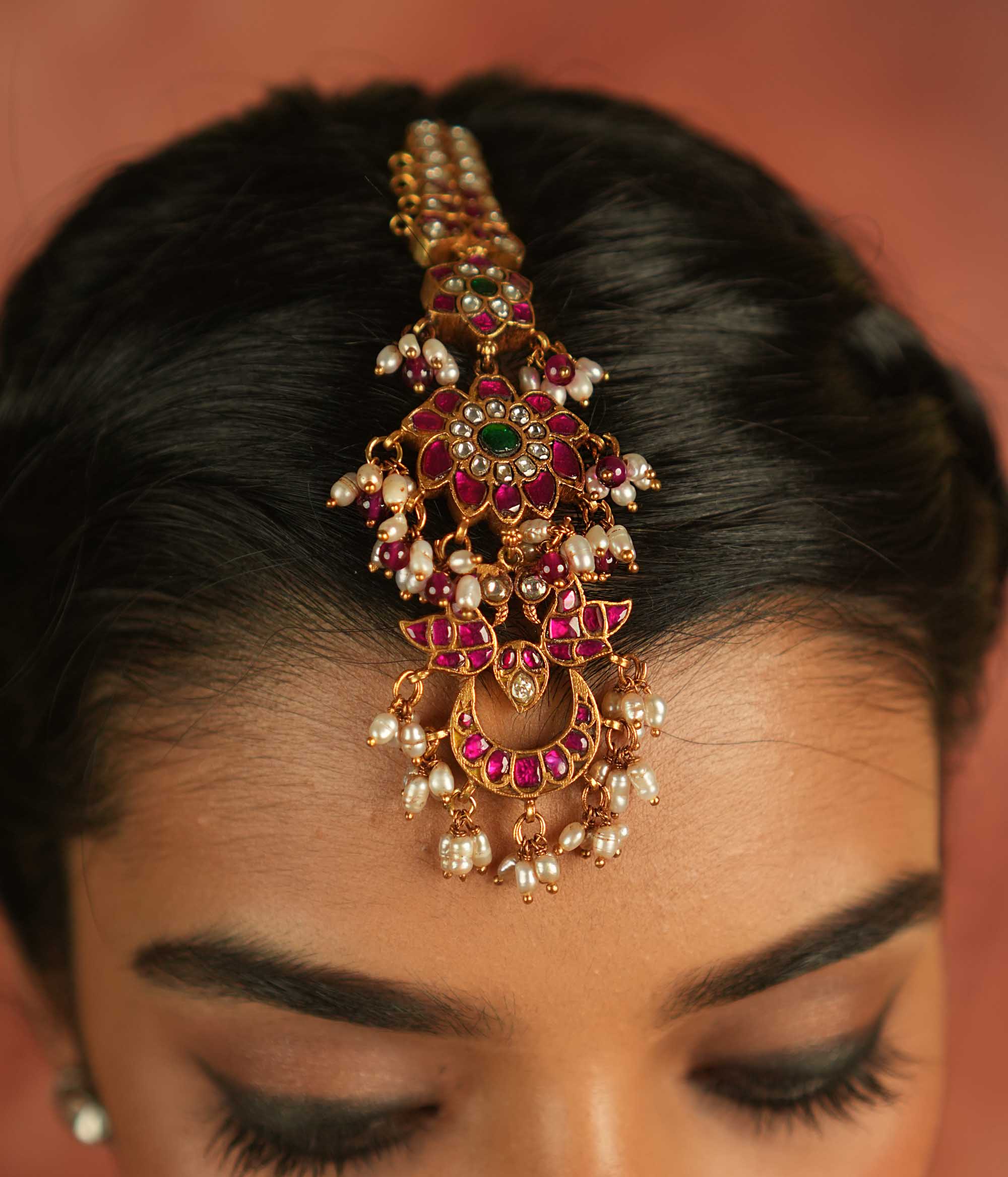 Ethereal bloom reborn! A floral Kundan maangtika adorned with pearls and red beads, where celestial grace meets timeless splendor.