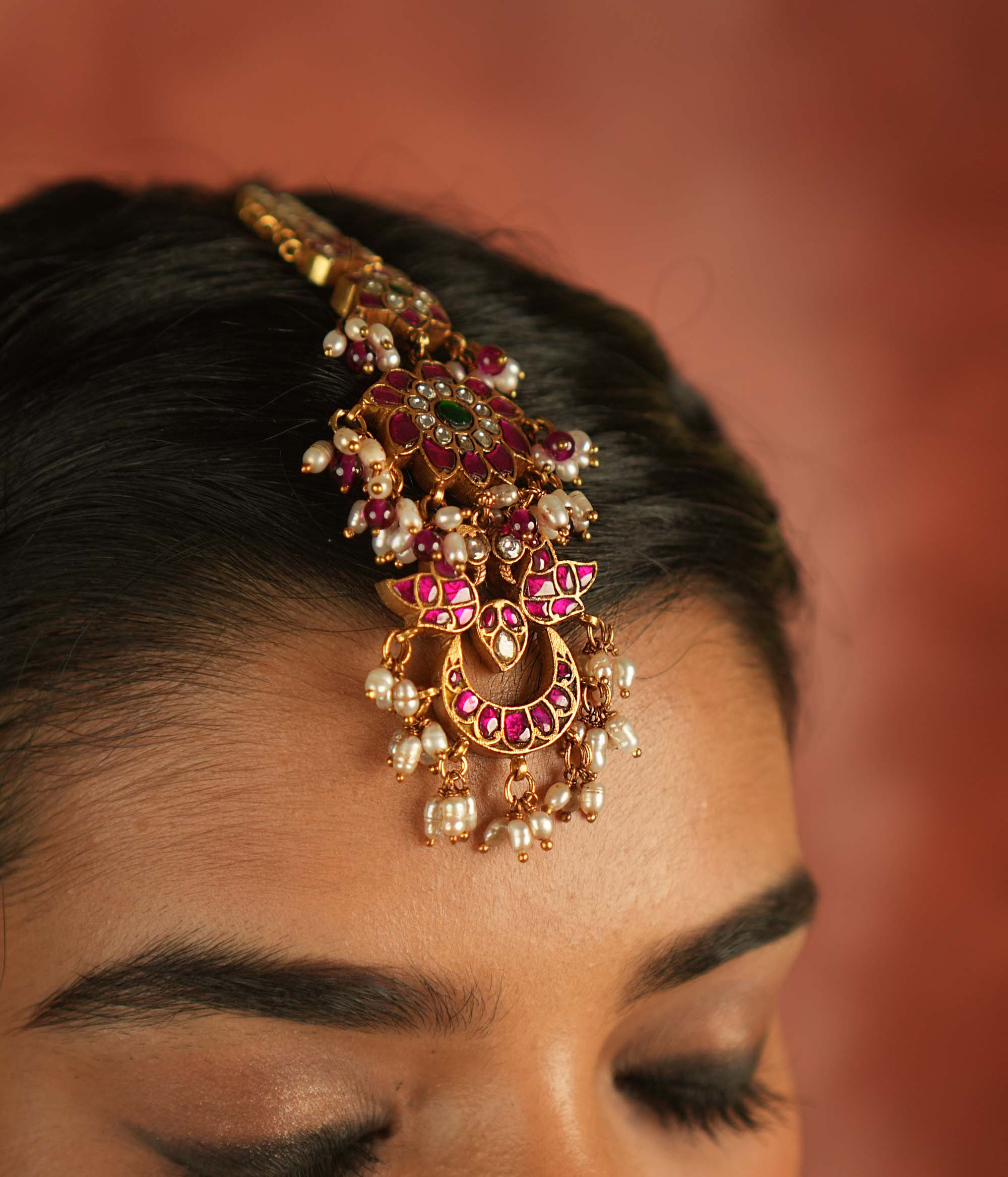 Ethereal bloom reborn! A floral Kundan maangtika adorned with pearls and red beads, where celestial grace meets timeless splendor.