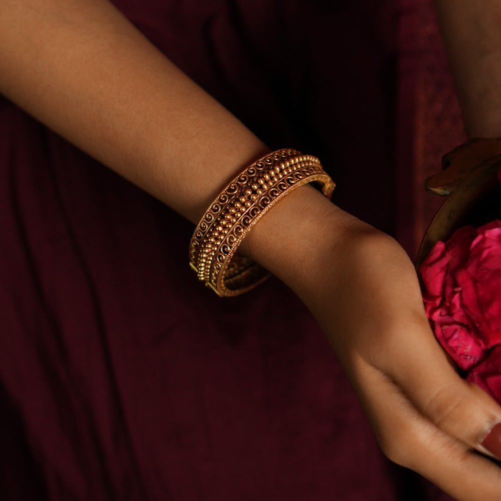 Avery Kada antique gold bangle with scrollwork.
