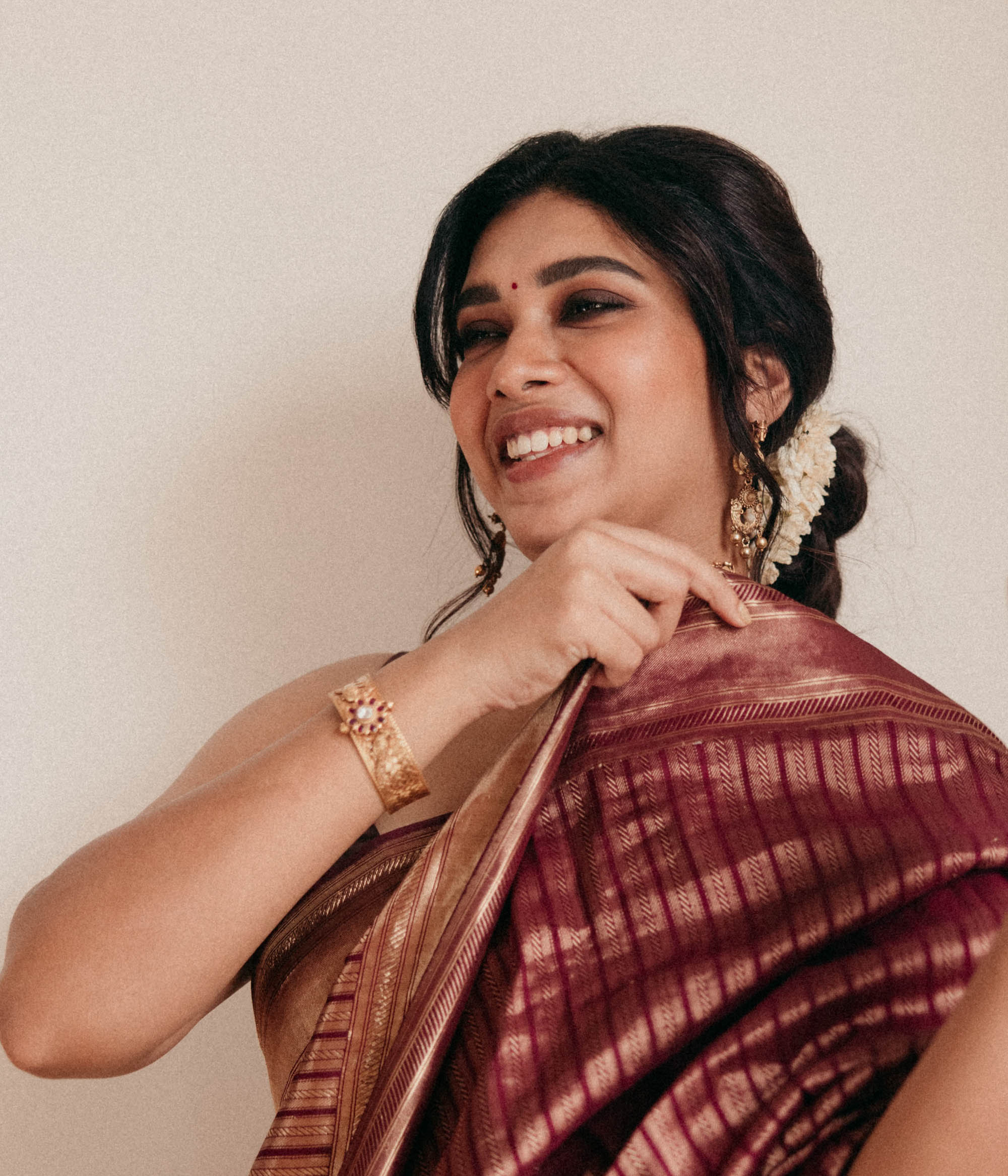 Antique gold tribal bangle with Red Spinal and White Kundan stones worn by model in saree.