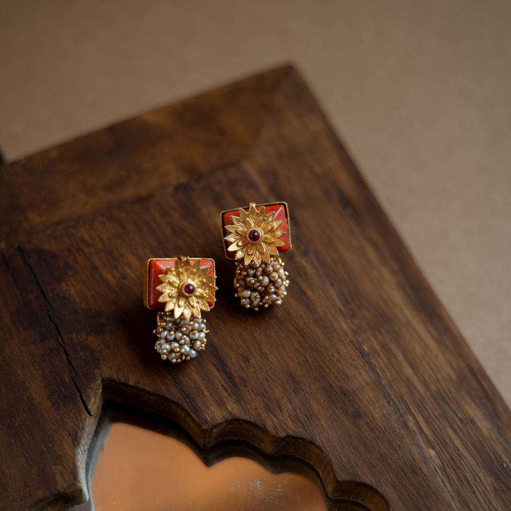 Bell-shaped earrings with a red spinel stone and pearl droplets.
