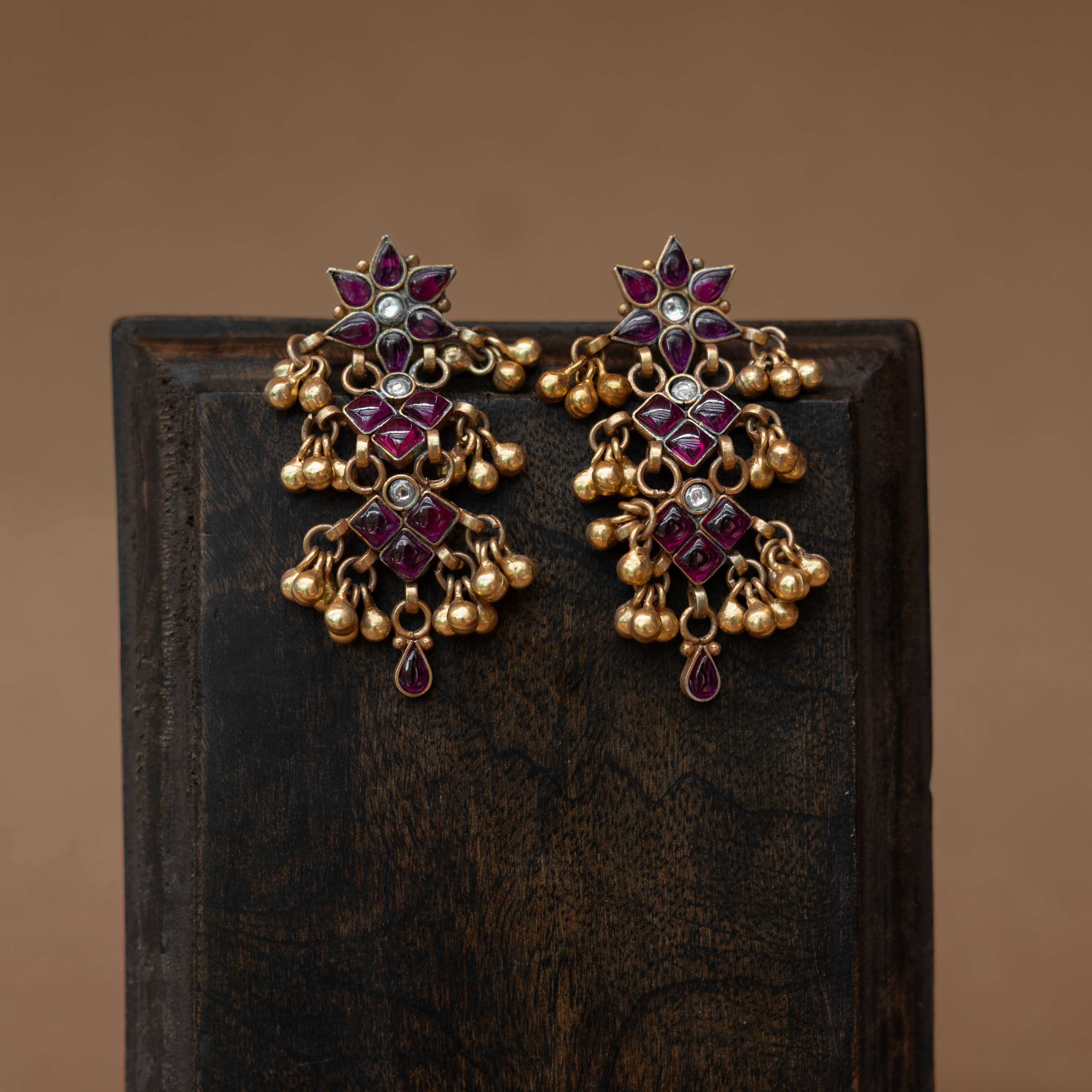 Tiered tribal earrings with red and white stones and small dangling drops.