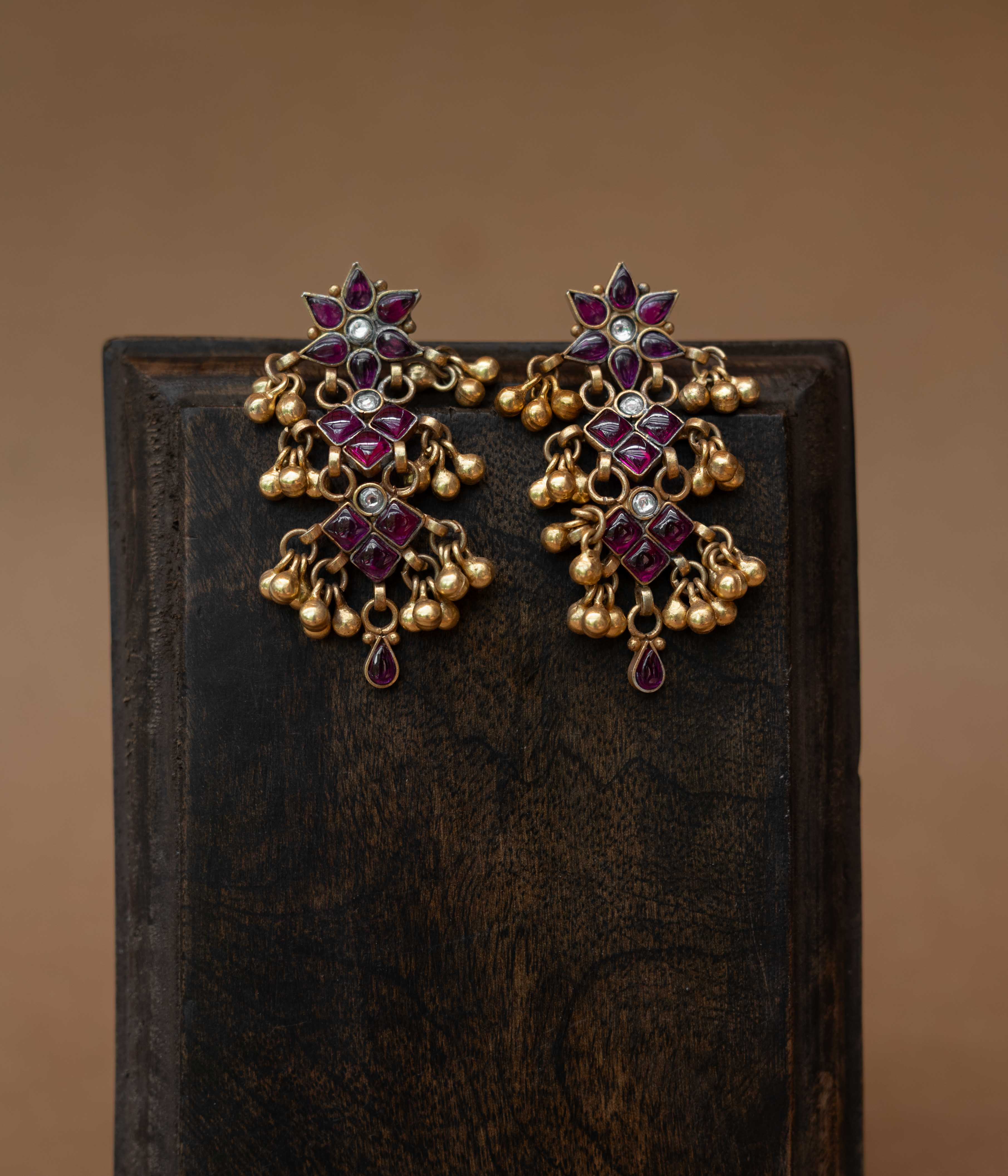 Tiered tribal earrings with red and white stones and small dangling drops.