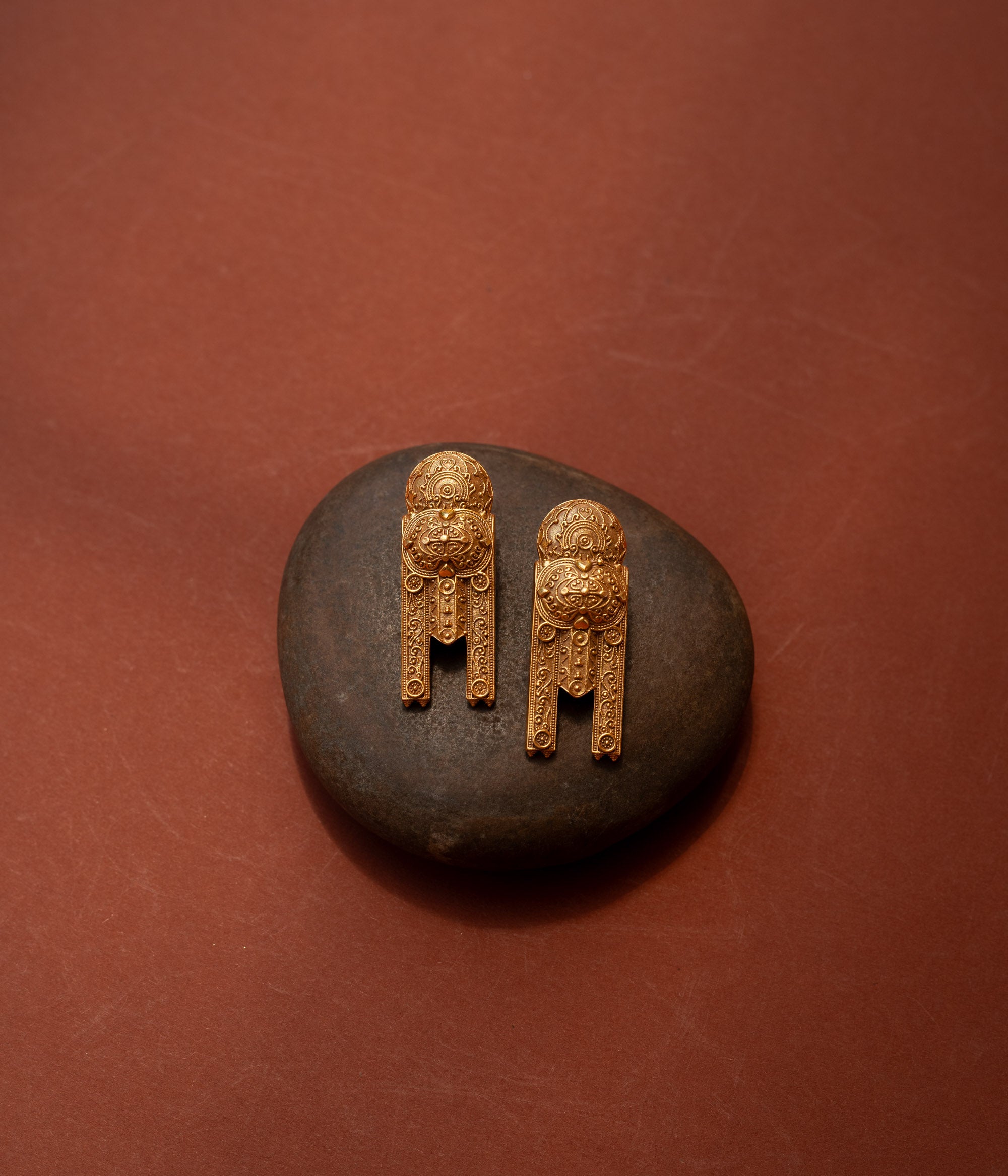 Gold tribal earrings with lion motif and yantra-inspired patterns from the Tribal Collection.