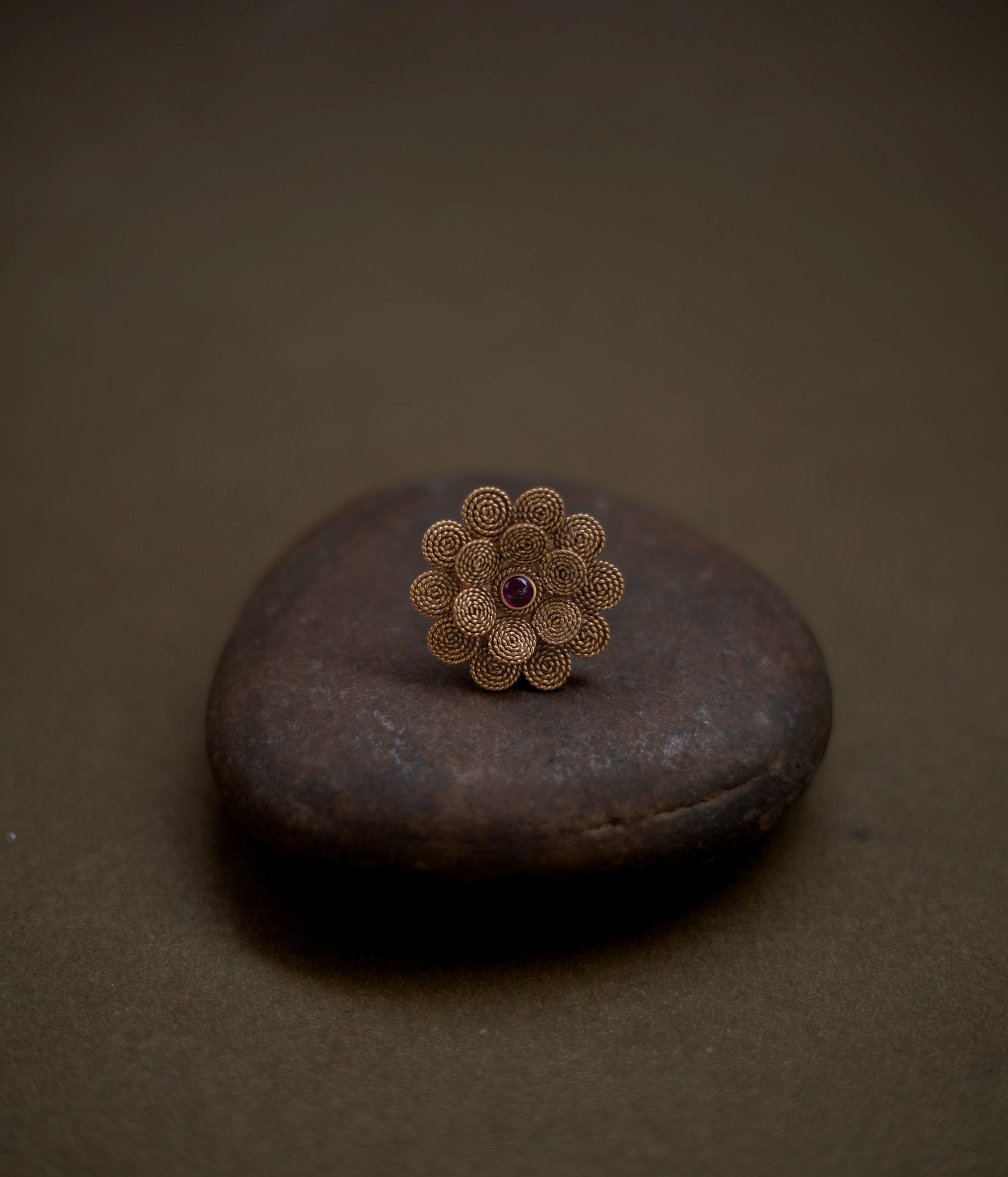 92.5 sterling silver ring with 22ct gold plating, featuring a delicate floral design centered with a radiant red spinel stone.