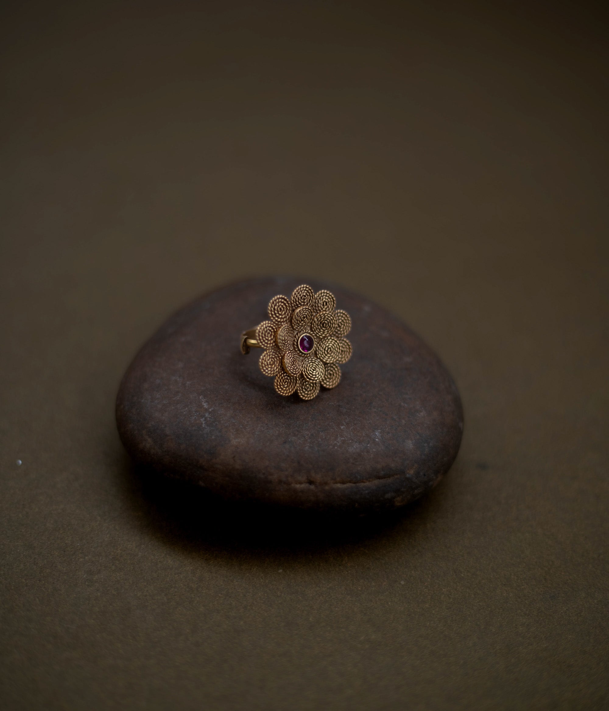 92.5 sterling silver ring with 22ct gold plating, featuring a delicate floral design centered with a radiant red spinel stone.