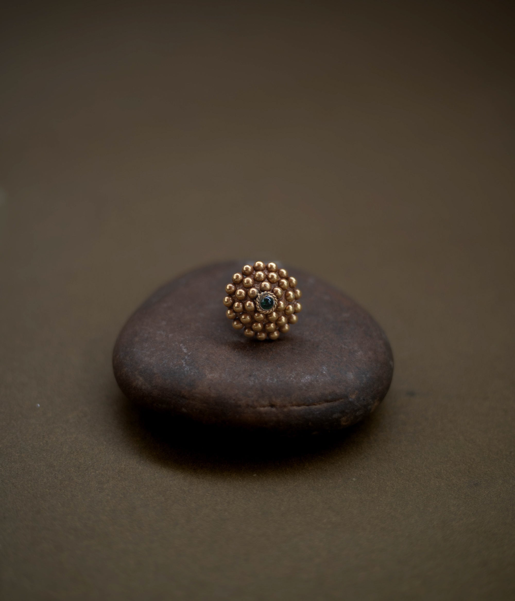 Tribal floral ring handcrafted from 92.5 sterling silver with rich 22ct gold plating, featuring a green spinel stone at the center.