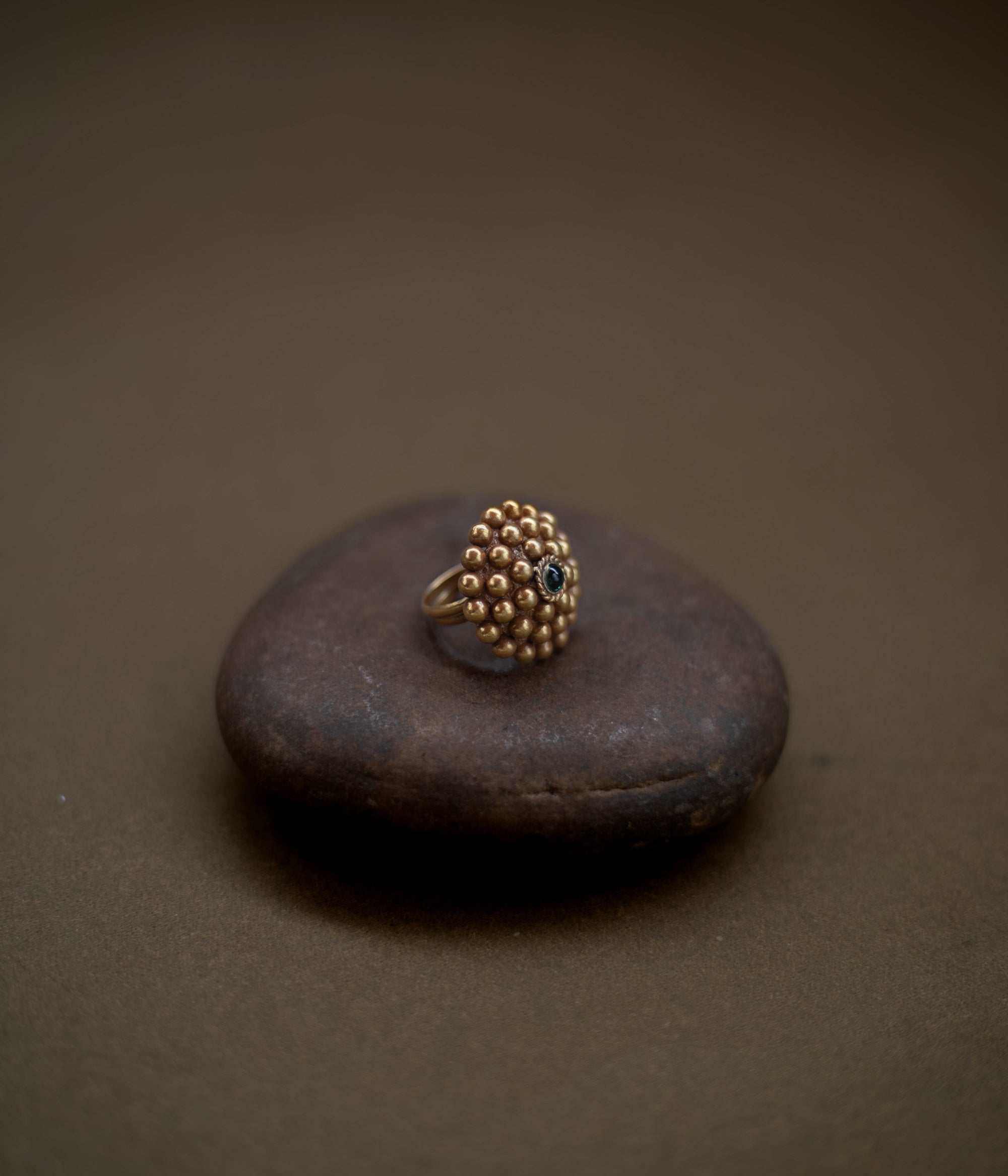 Tribal floral ring handcrafted from 92.5 sterling silver with rich 22ct gold plating, featuring a green spinel stone at the center.