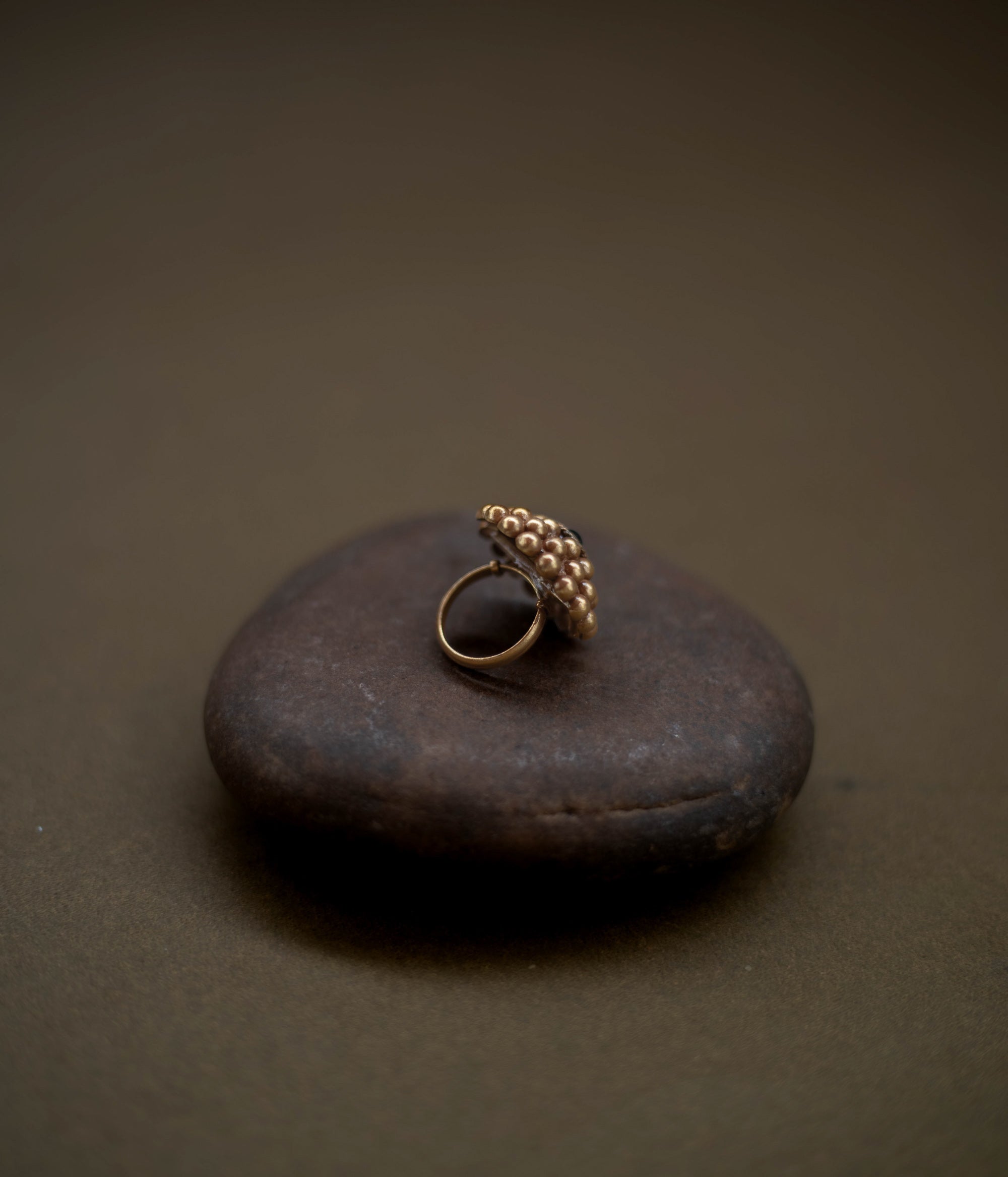 Tribal floral ring handcrafted from 92.5 sterling silver with rich 22ct gold plating, featuring a green spinel stone at the center.